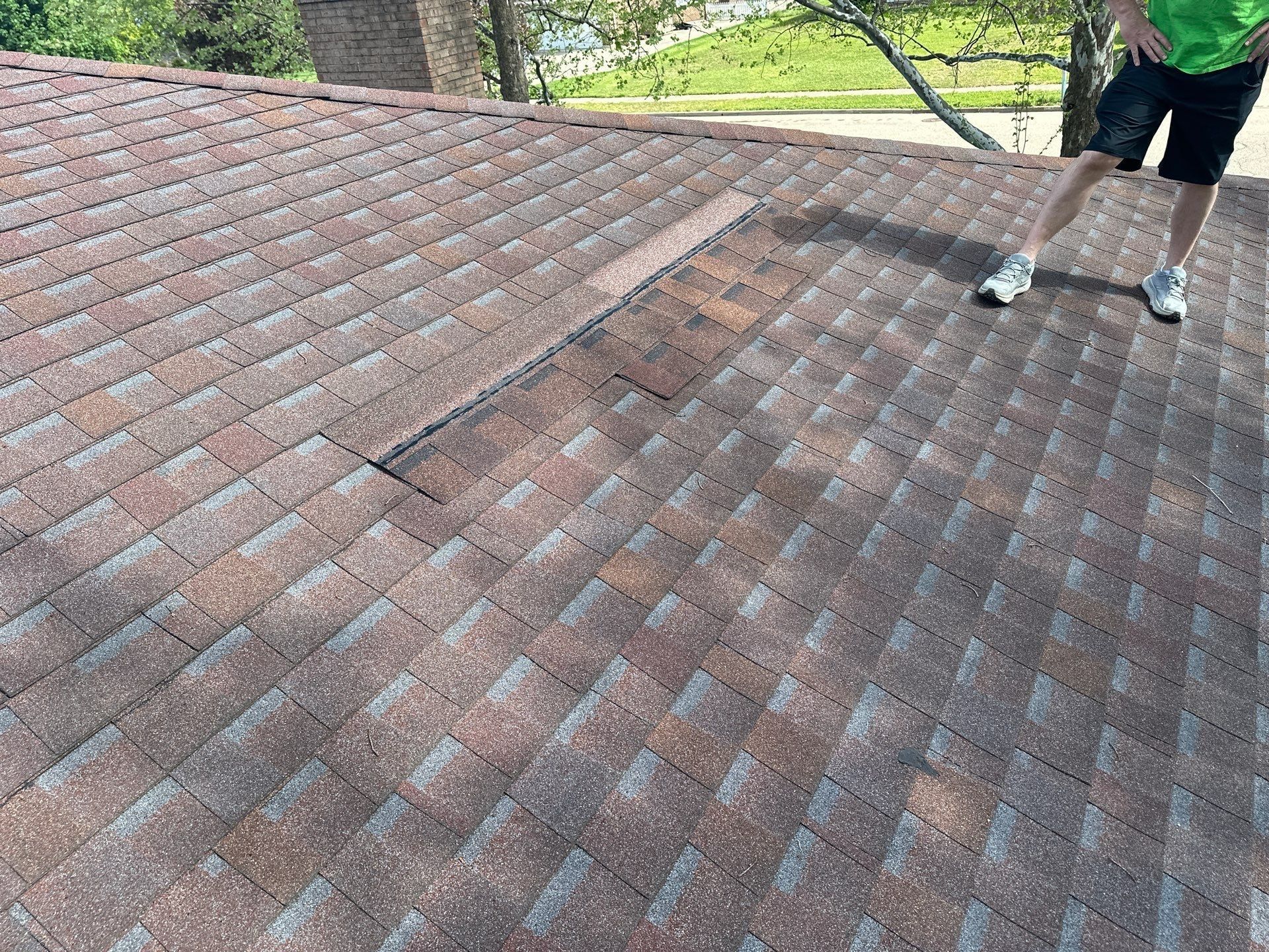 Standing on the roof with the homeowner at the inspection, where the original gray-topped shingles meet a strip of black sample shingles, Dayton, Ohio.