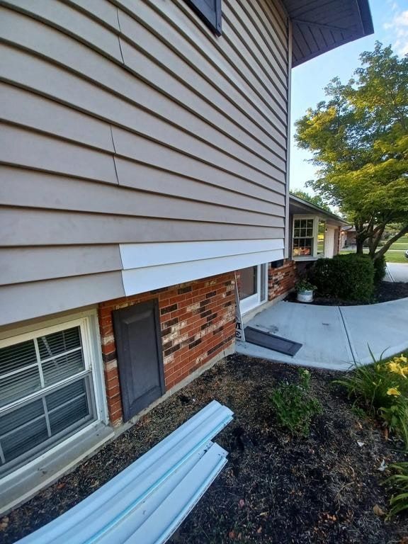 Loose and missing siding above the brick on the side of the house, Beavercreek, Ohio.