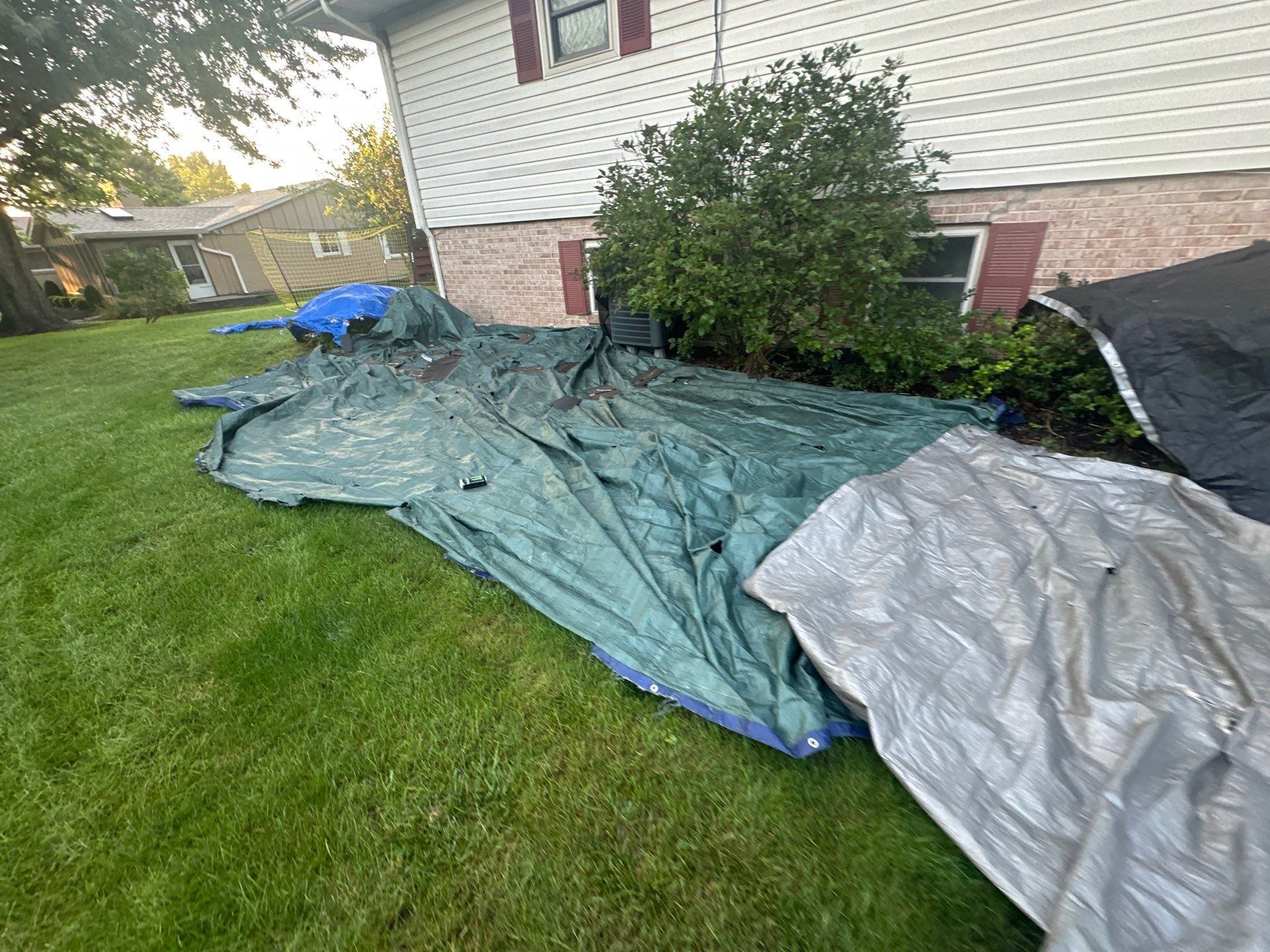 Green tarps along the side of the house below the upper windows, Dayton, Ohio.