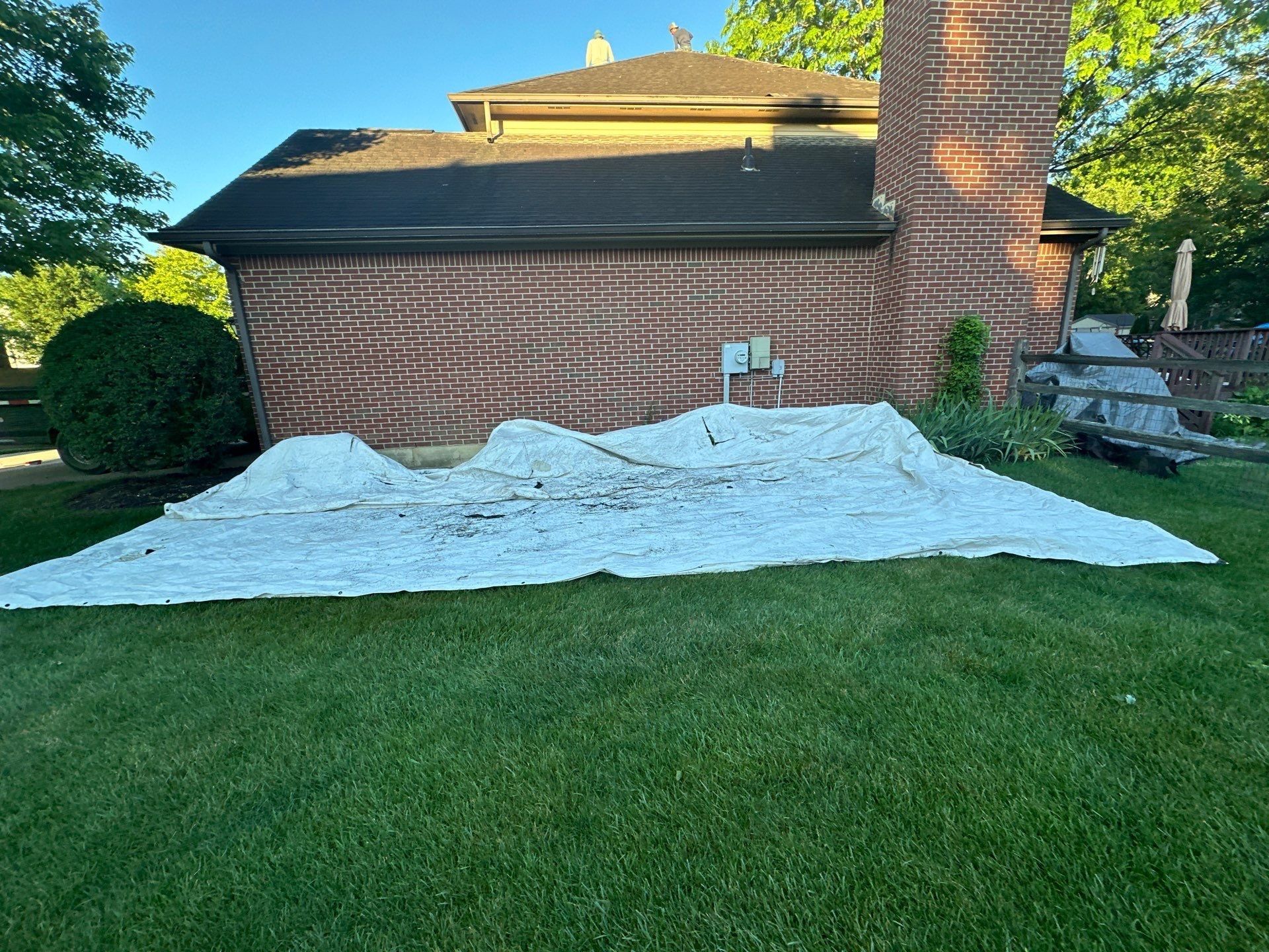 Tarp spread across the side lawn below the brick wall, Beavercreek, Ohio.