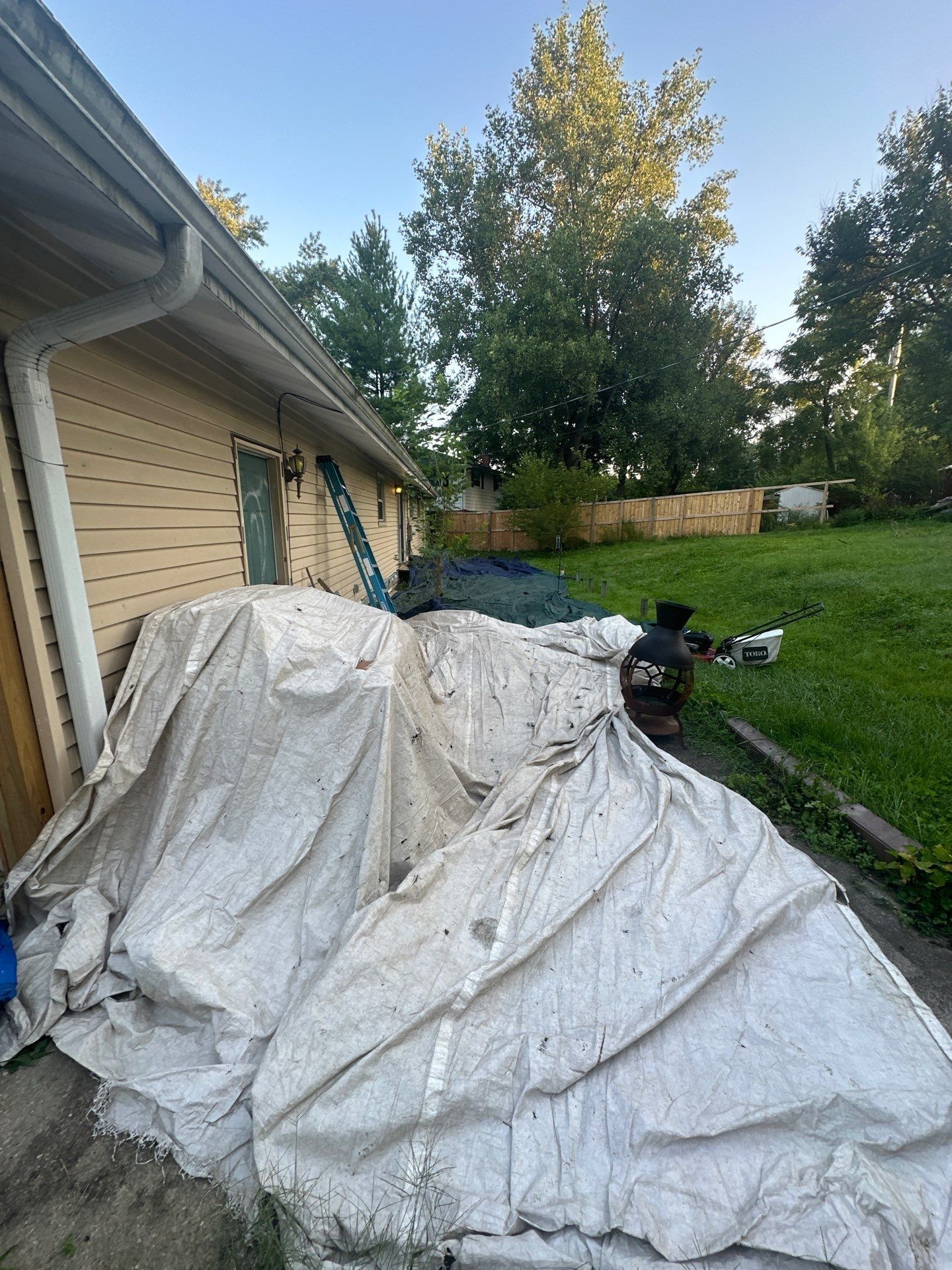 White tarps covering the patio and yard along the back of the house, Fairborn, Ohio.