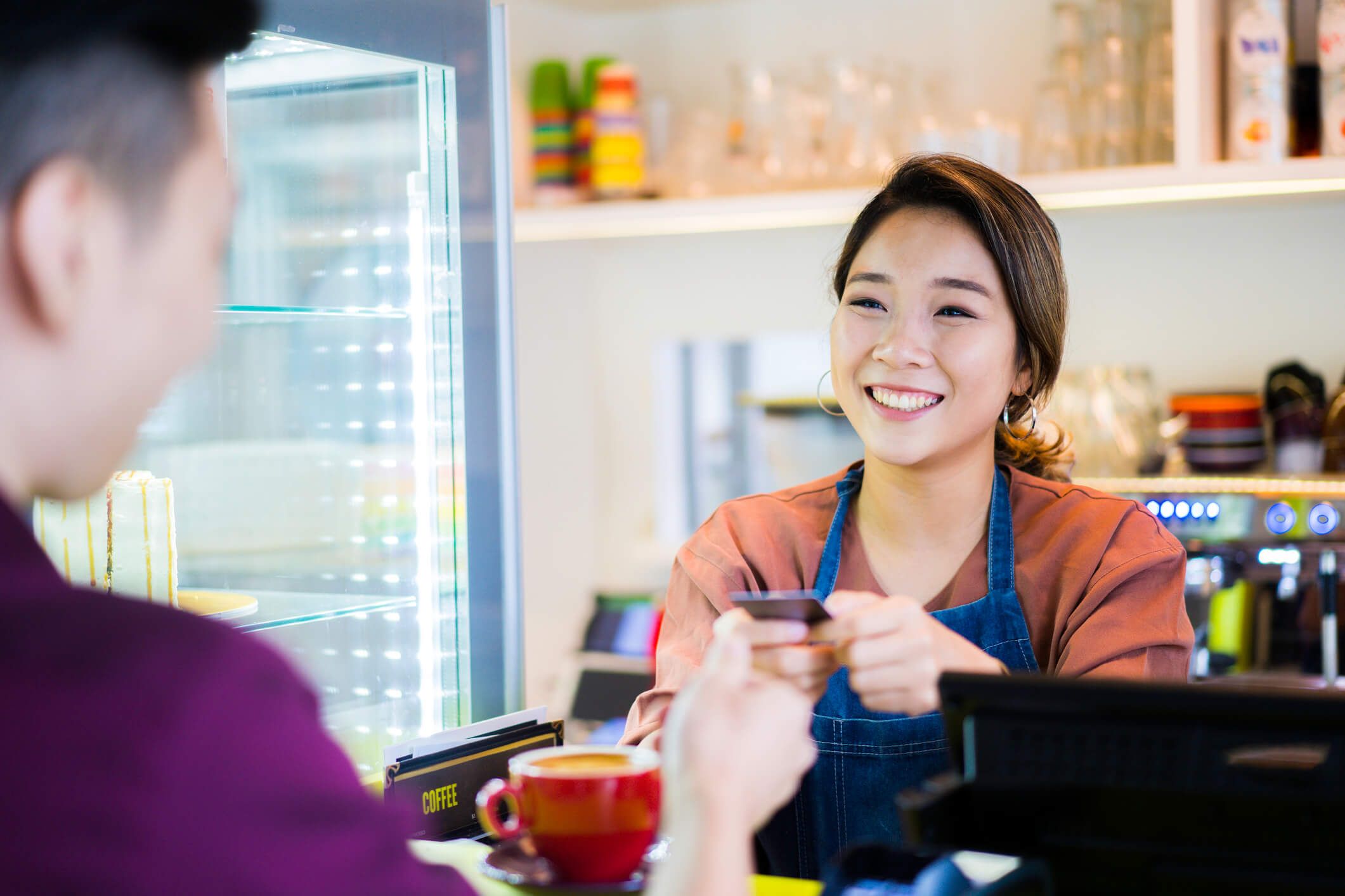 Cafe customer paying for their beverage with a credit card