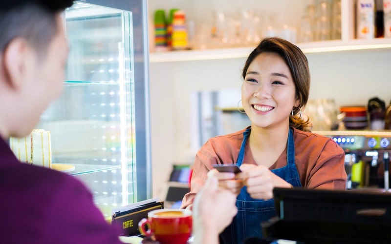 Cafe customer paying for their beverage with a credit card