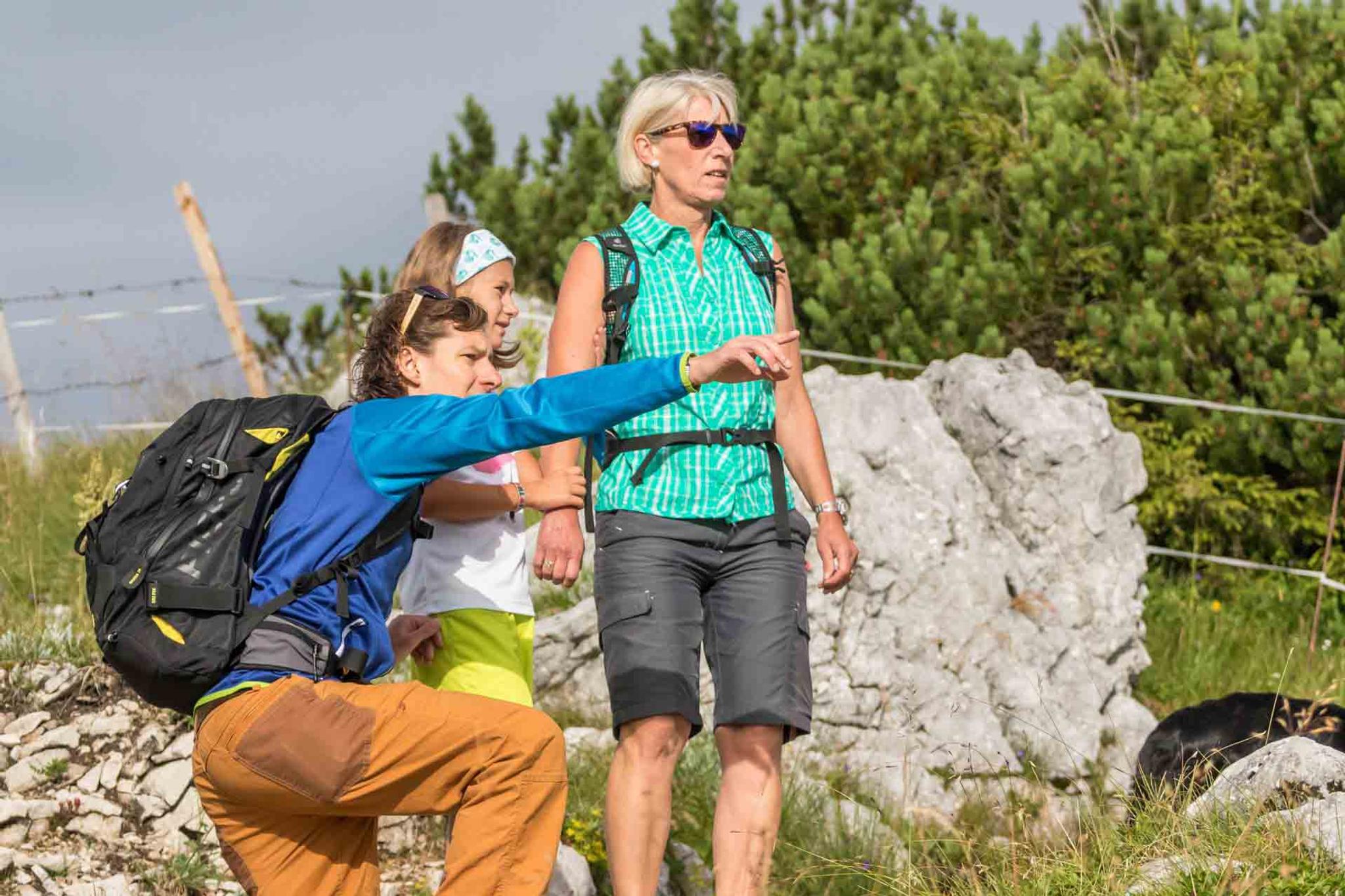 Vater, Mutter und Kind stehen zusammen und beobachten Tiere
