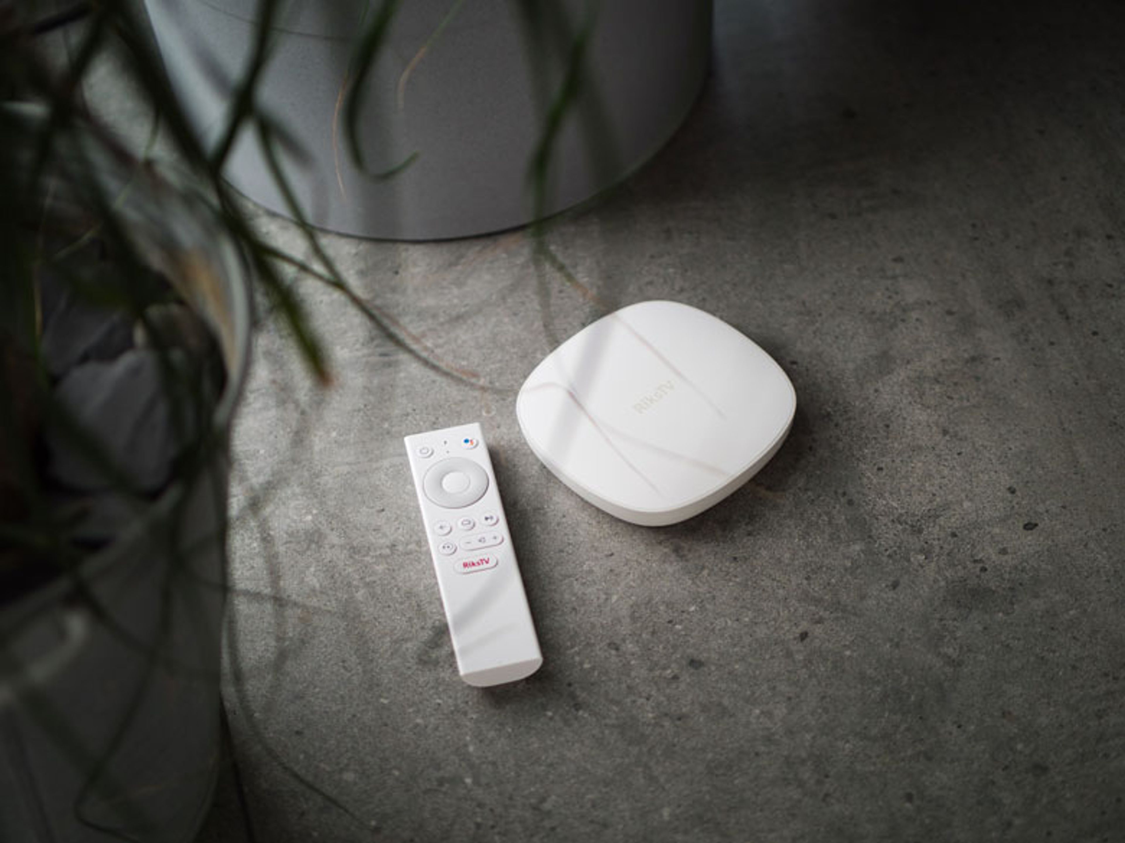 Bilde av RiksTVs Strømmeboks og tilhørende fjernkontroll som gir deg en enkel brukeropplevelse når du skal se på TV.