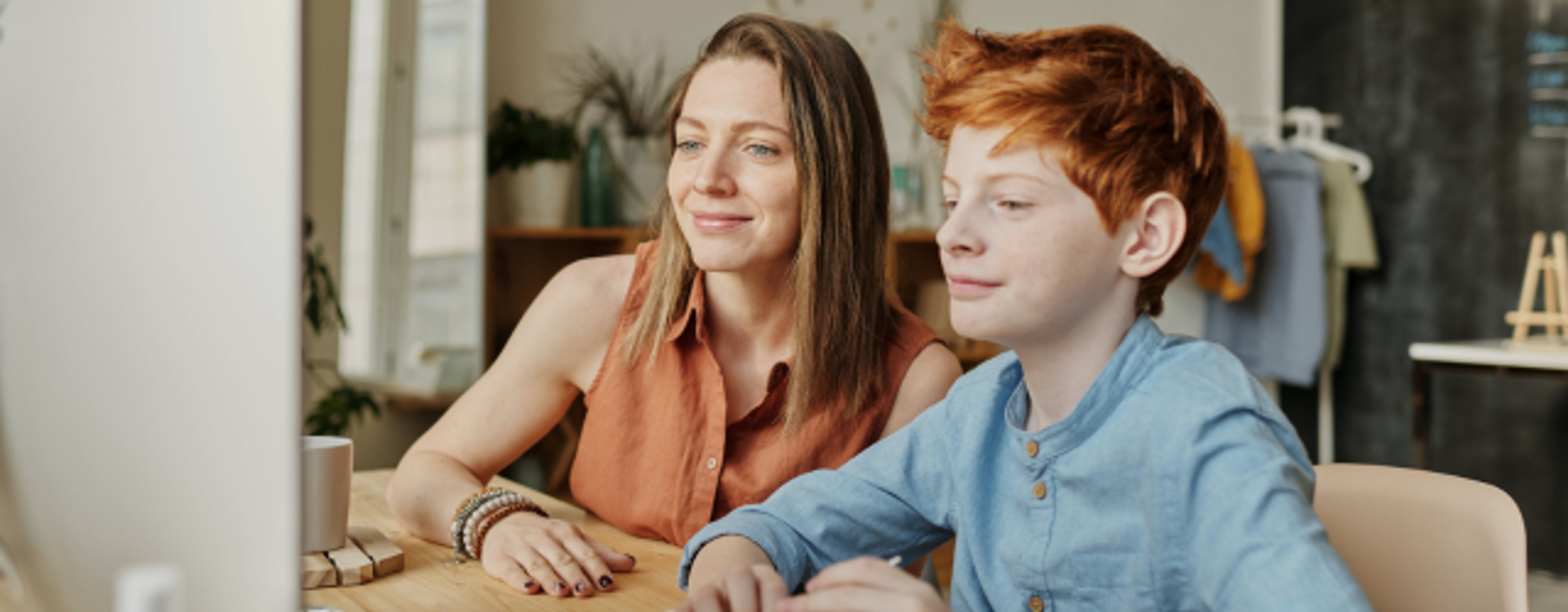 Mor og sønn som sitter foran pc
