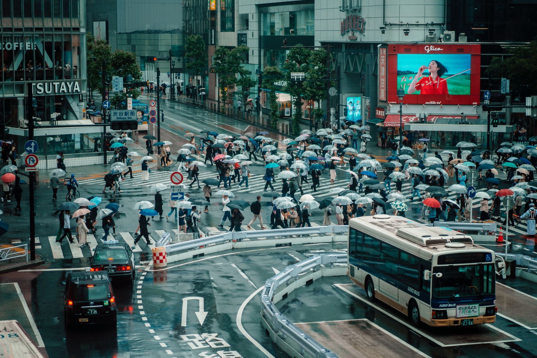 Crowds cross Tokyo's Shibuya intersection under umbrellas on a rainy September day