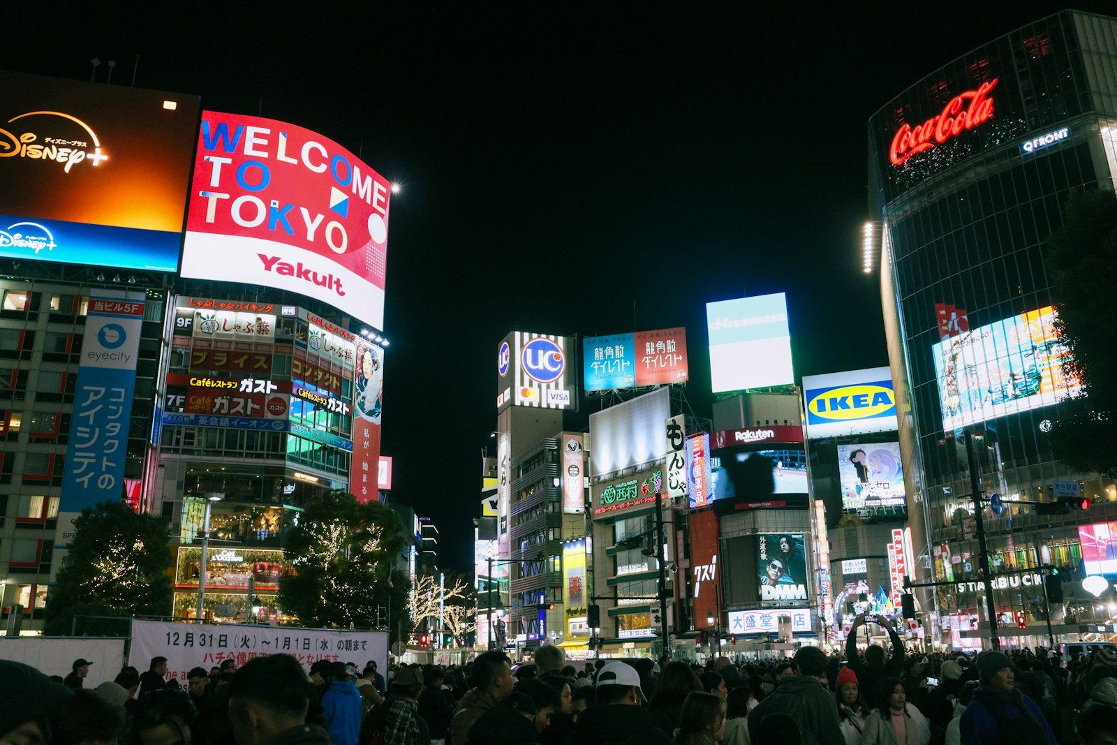 Pedestrians crossing Shibuya Crossing at night under neon signs, Tokyo