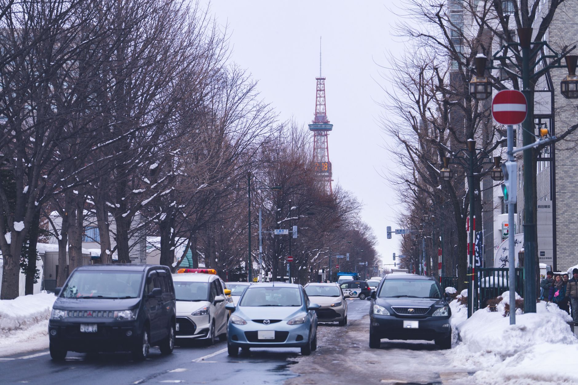 Snow-covered street in central Sapporo in winter, with the Sapporo TV Tower at the end of the block