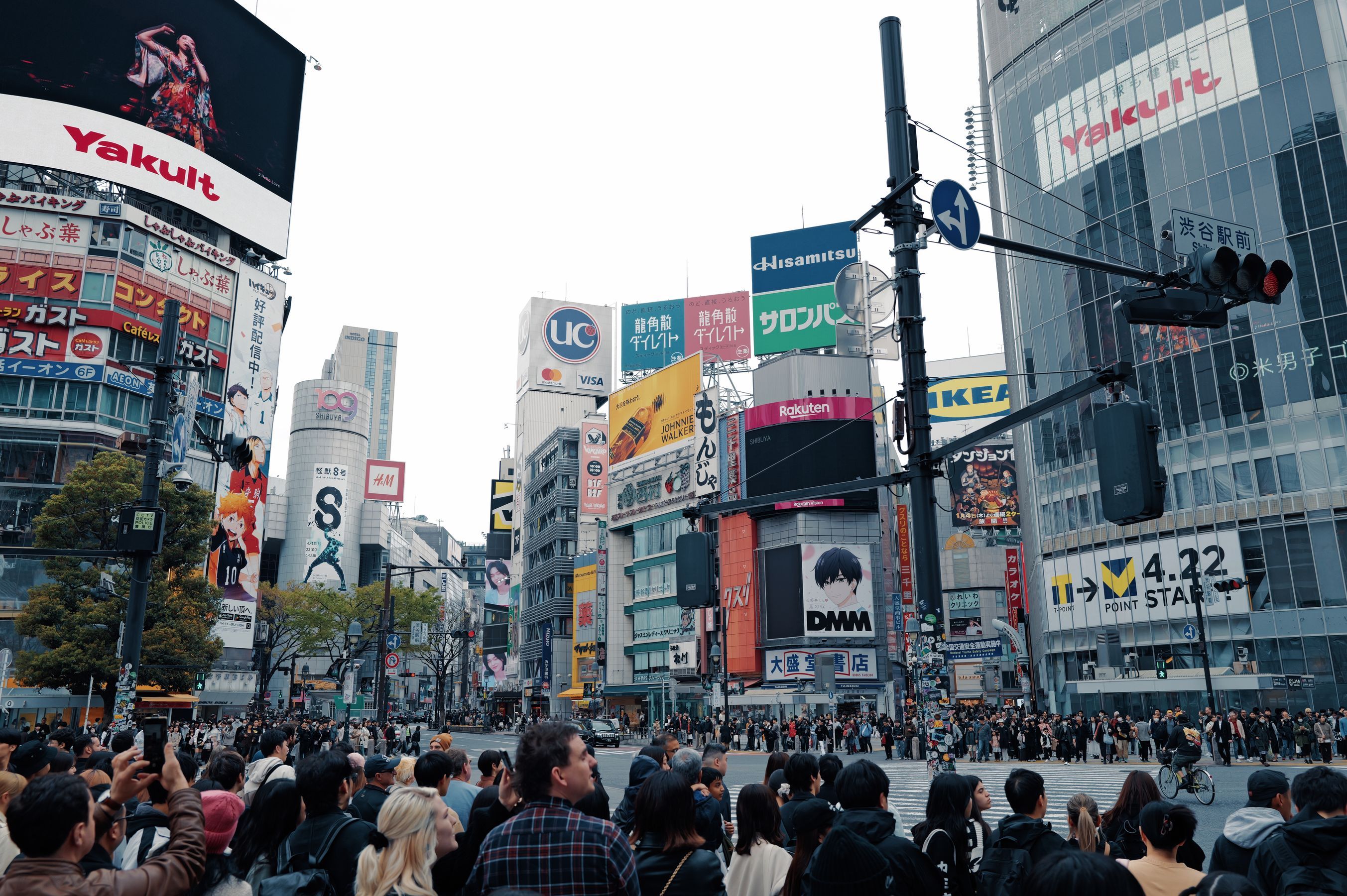 Crowds crossing Shibuya scramble in central Tokyo on a bright summer day