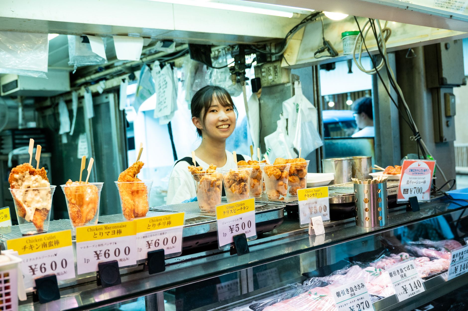 A Japanese street food vendor serving fried snacks at a stall, where a casual meal costs around 1,000 yen