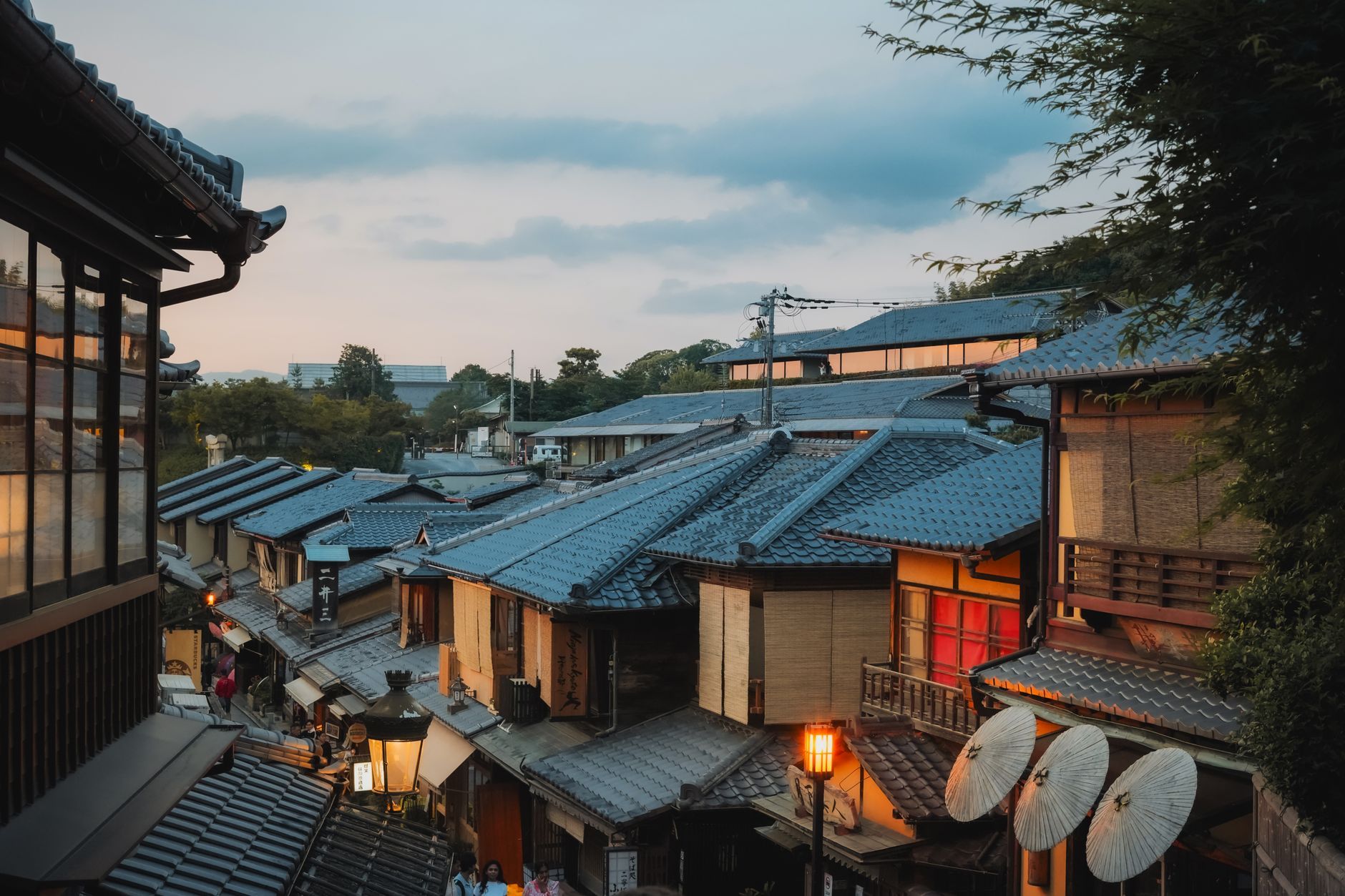 Traditional wooden machiya houses on a quiet street in Kyoto's historic Higashiyama district at dusk