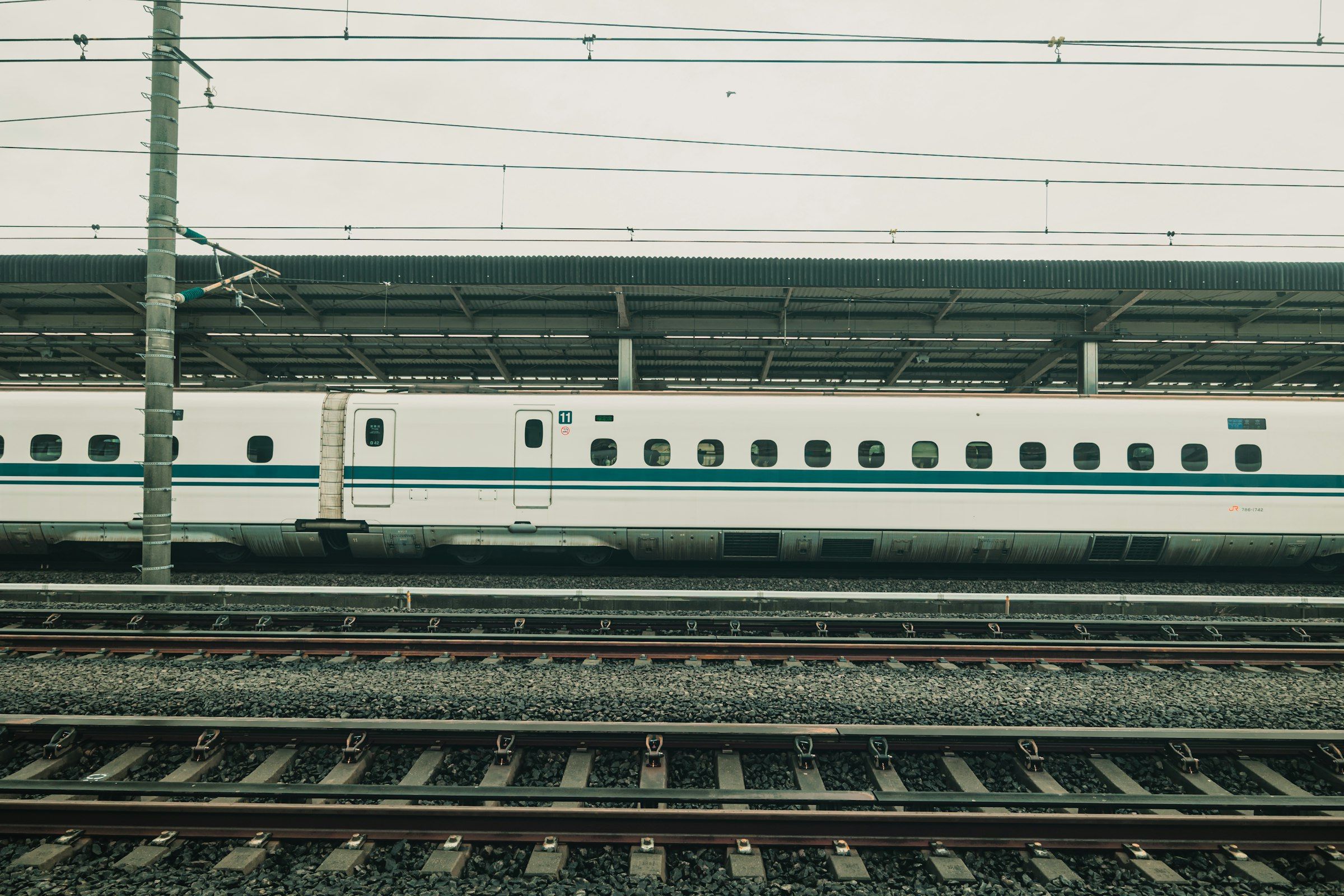 White Shinkansen bullet train waiting at a station platform in Japan