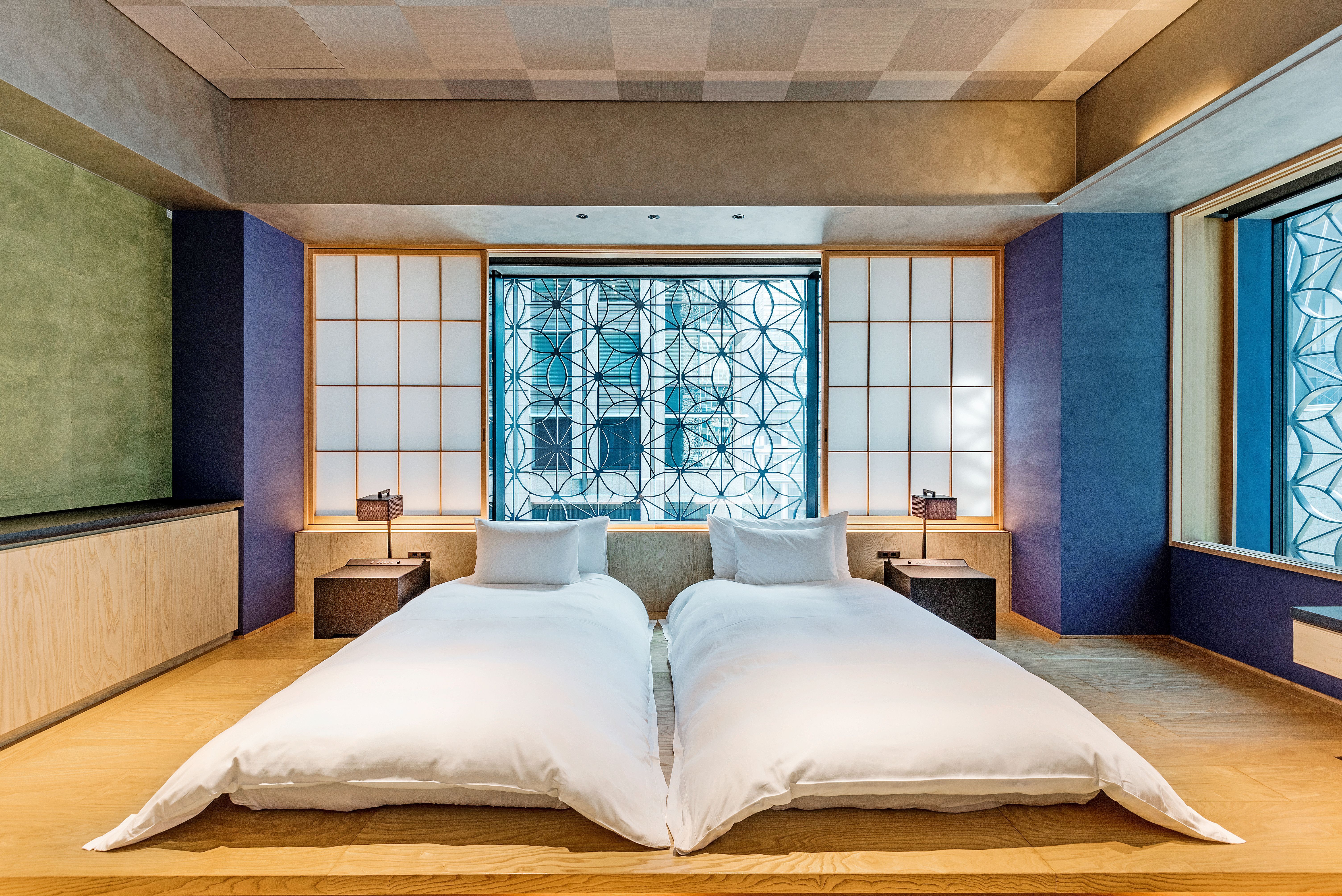 Japanese hotel room with two single beds, wooden floor and a low table by the window