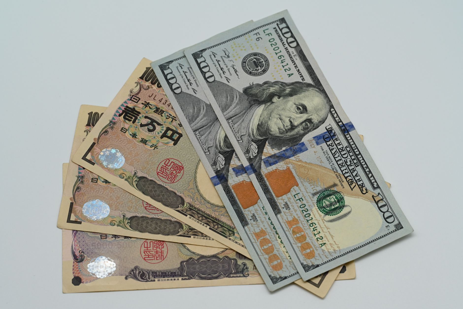 US dollar bills and Japanese yen banknotes side by side, illustrating the yen exchange rate for budgeting a Japan trip