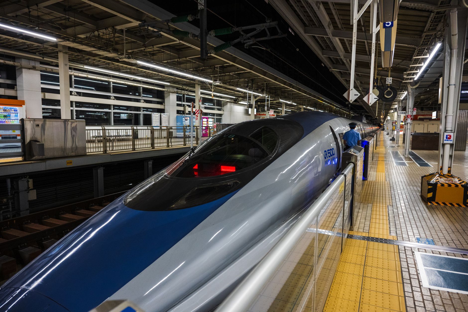 Sleek bullet train stopped at a well-lit station platform during the night in Japan