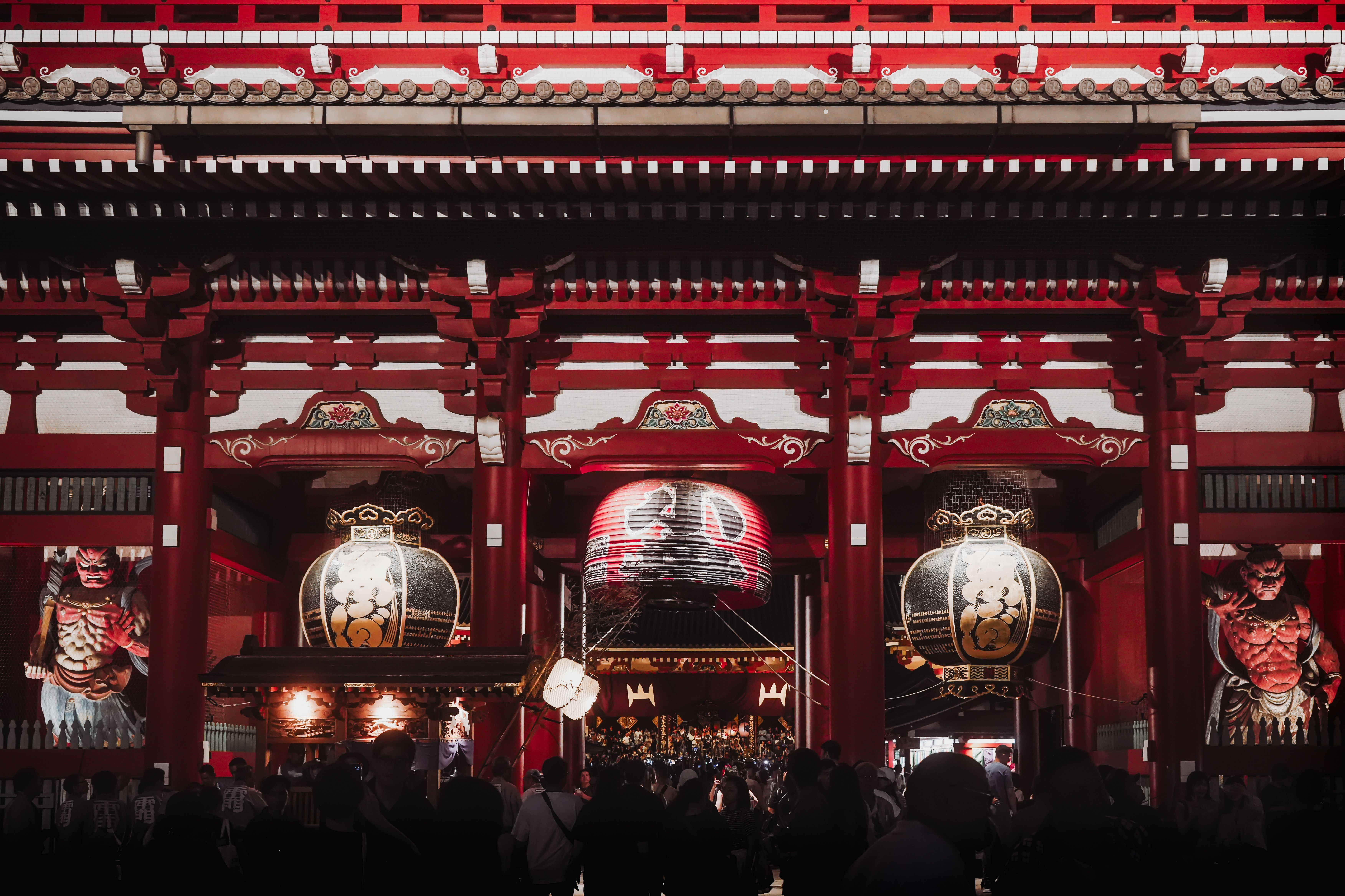 Senso-ji temple in Asakusa, Tokyo, lit up at night with visitors on the approach to the main hall