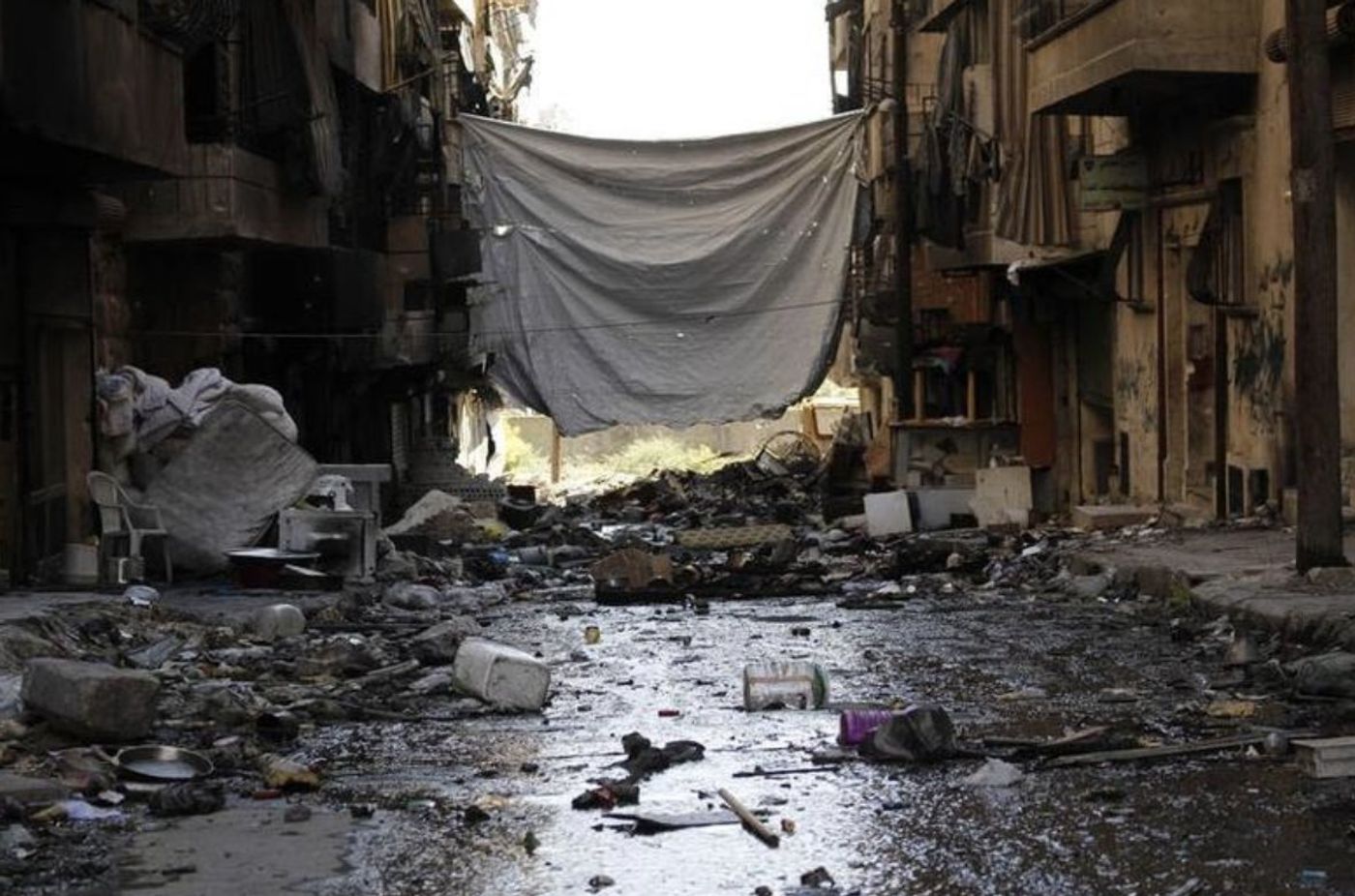 A sheet strung across a street to block snipers' line of sight — Sheikh Maksoud, Aleppo, 2013