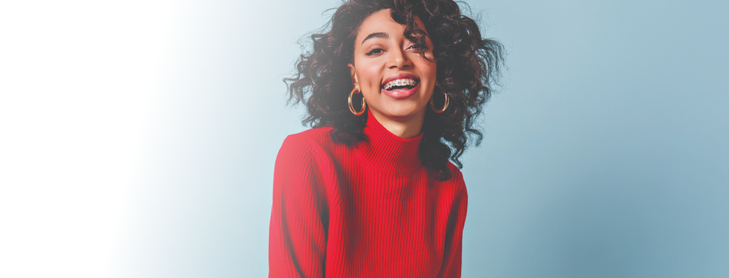 Smiling woman with braces in a red sweater