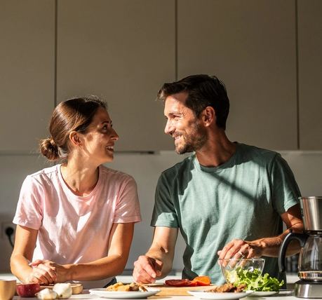 Due persone parlano in cucina, una si avvicina leggermente.