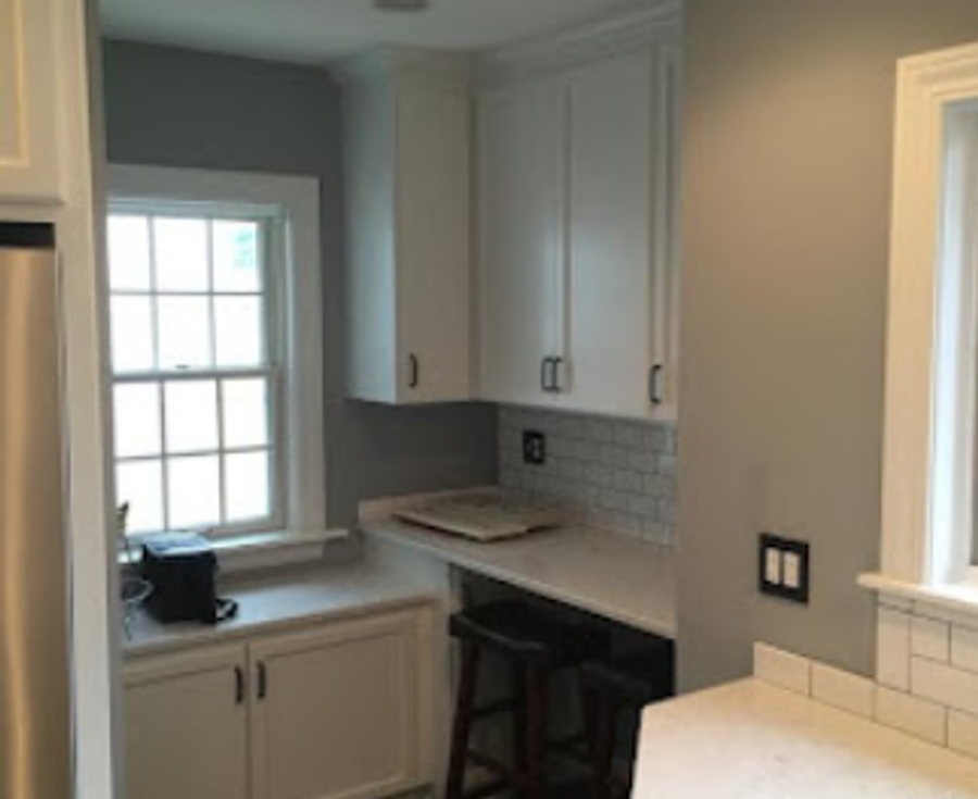 Newly finished kitchen with white cabinets, subway tile backsplash, and built-in desk