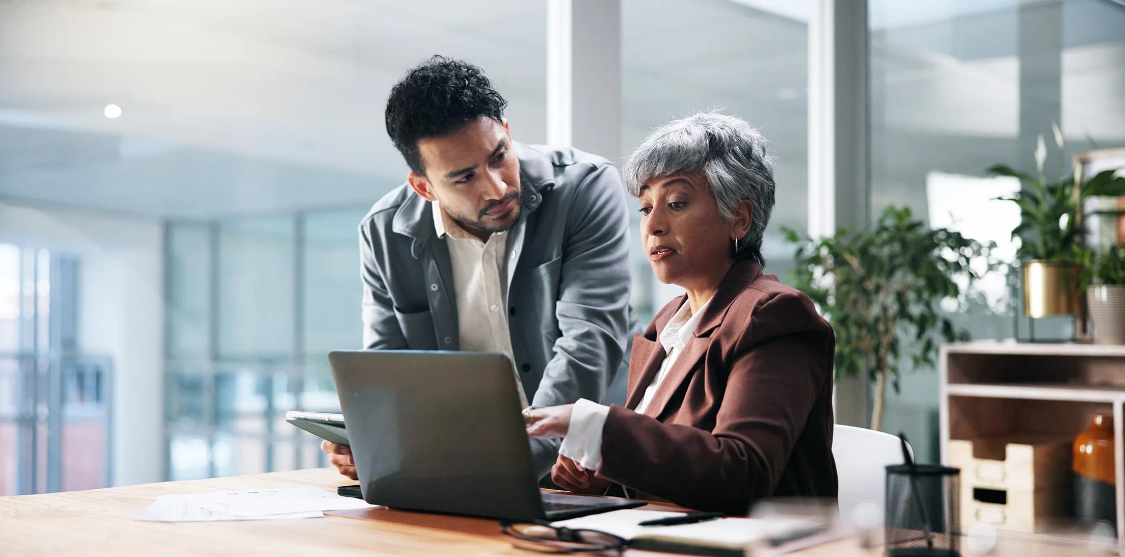 An advisor and a client reviewing information on a laptop
