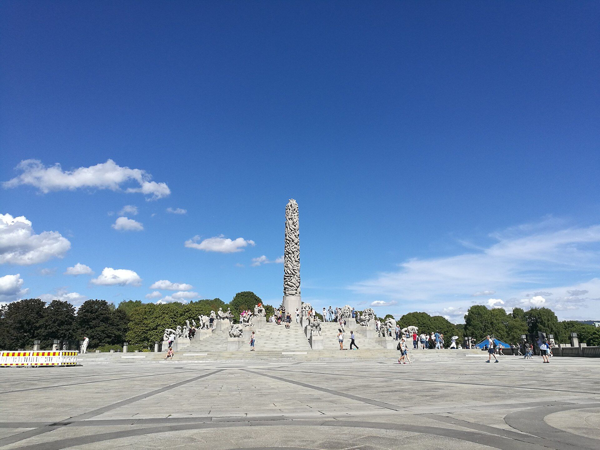 The completed Monolith and surrounding granite groups, with summer trees and visitors on the steps.