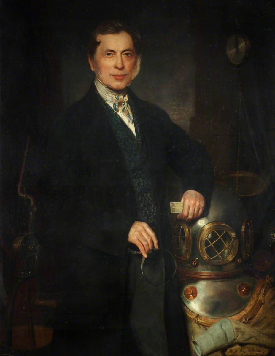 Augustus Siebe holding a slide rule beside a diving helmet, suit and workshop equipment