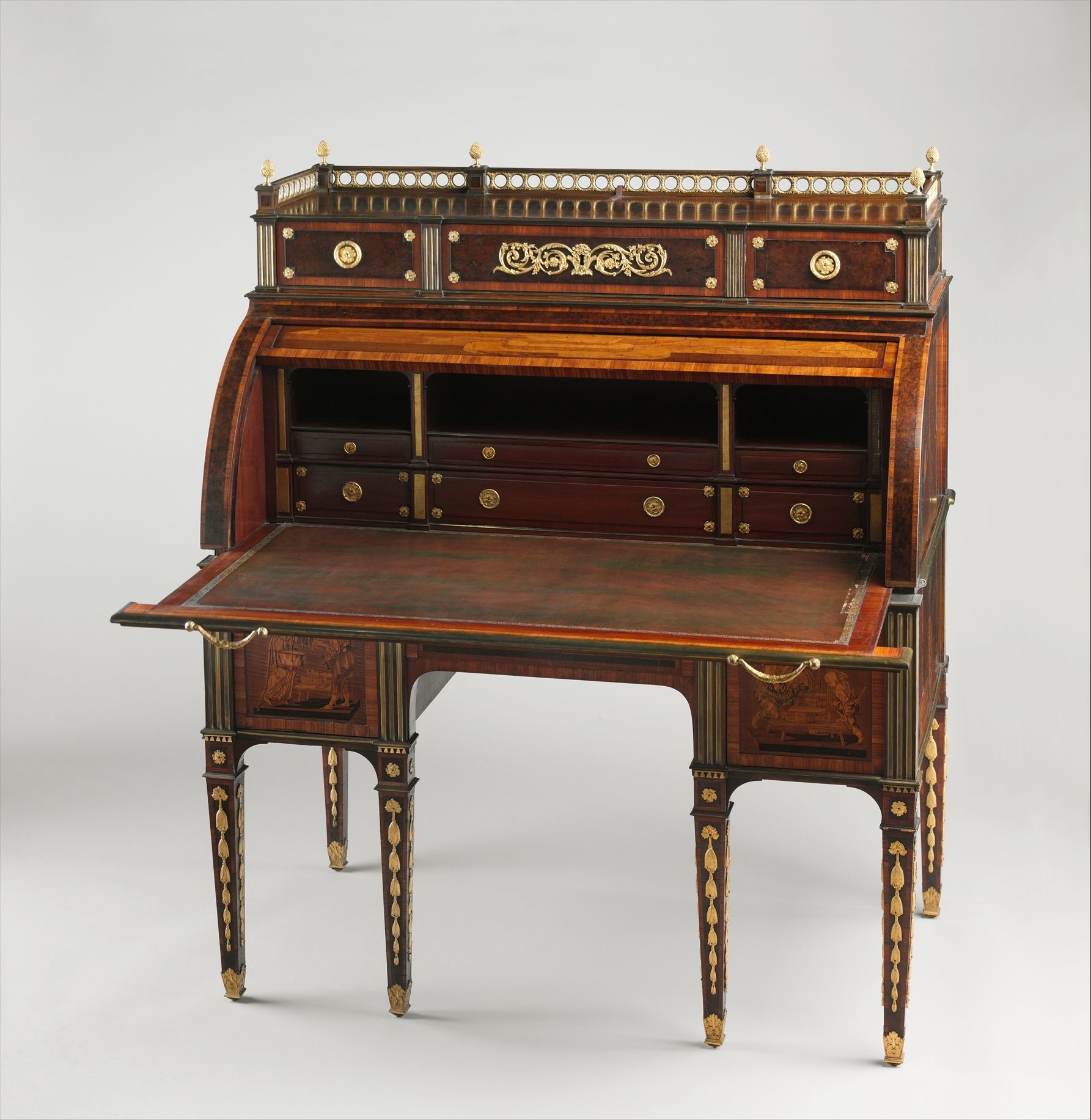 The curved top of a marquetry desk is raised, exposing a writing surface and rows of compartments.