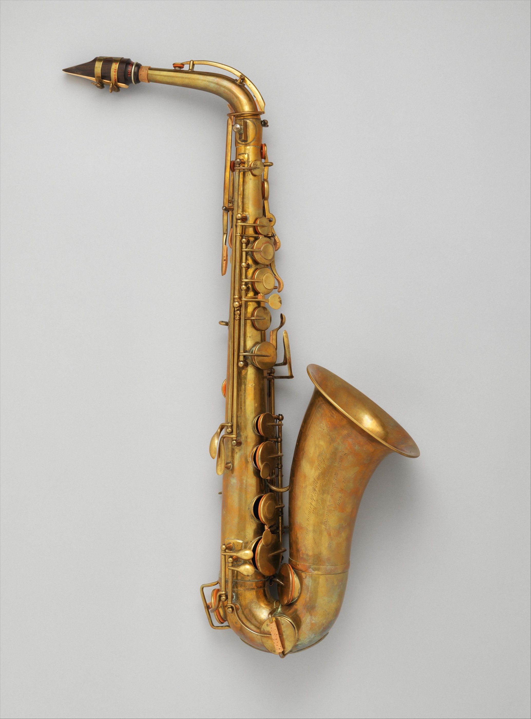 An early alto saxophone with a curved neck and upward-facing bell