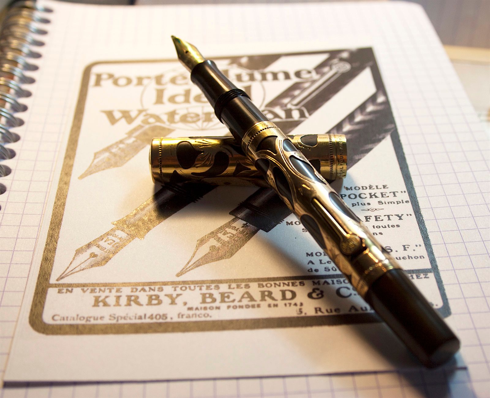 Uncapped black and gold Waterman 0514 PSF fountain pen, with its separate cap resting behind it