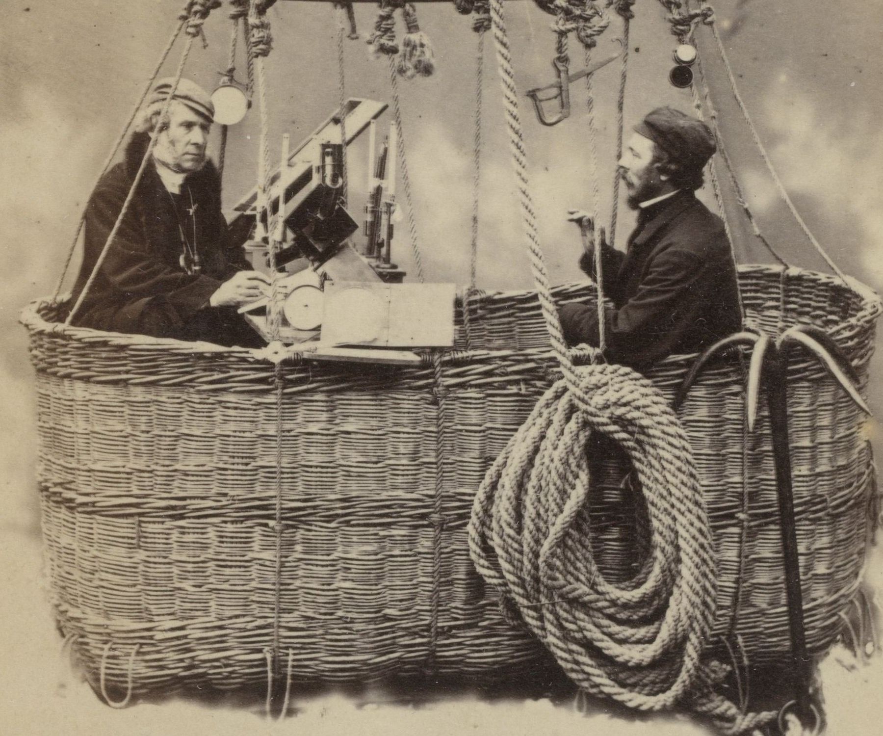 Glaisher and Coxwell on either side of the scientific instrument table in a balloon basket