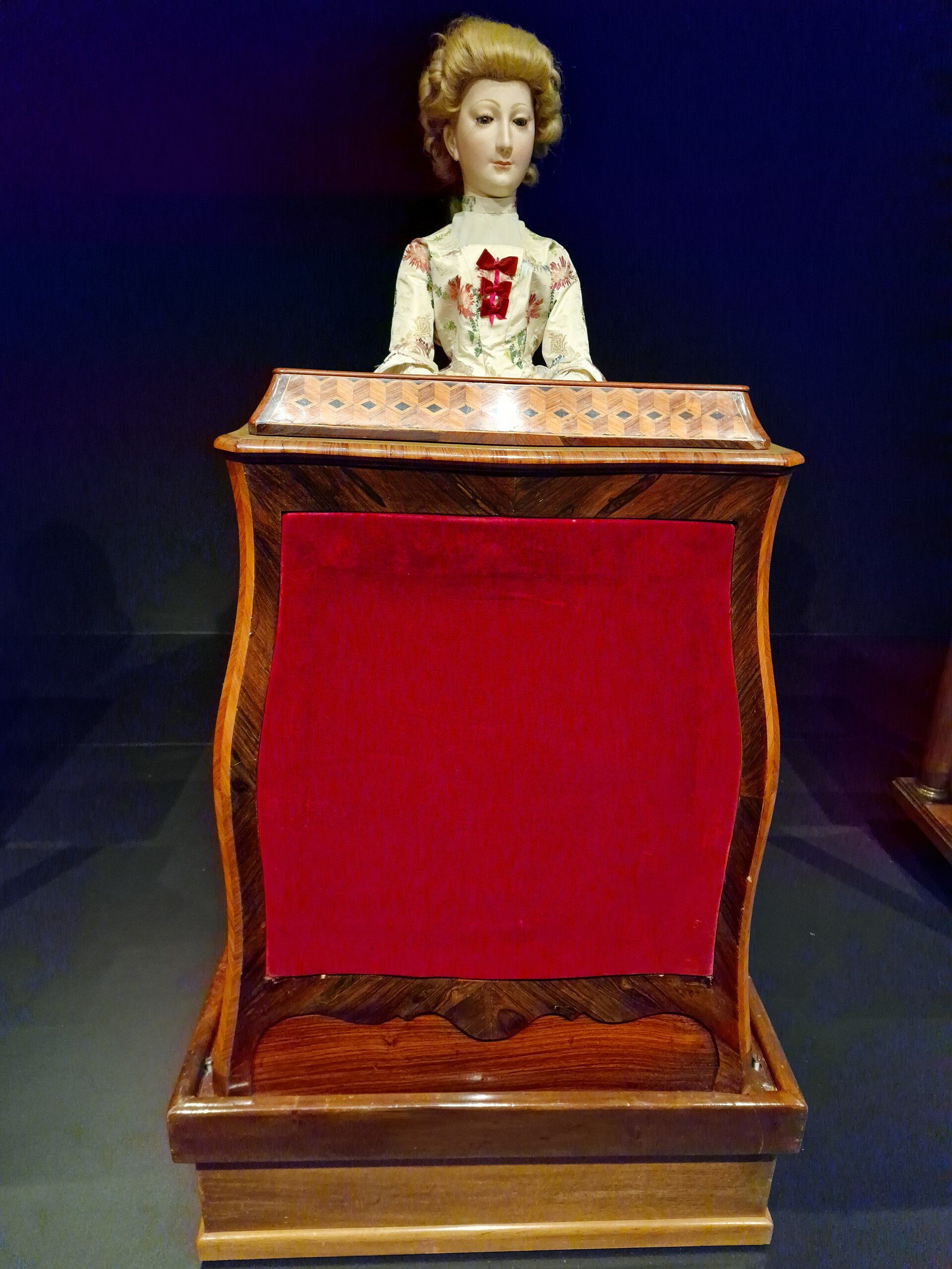 The Musician, a seated woman in a full skirt, playing a small keyboard instrument.
