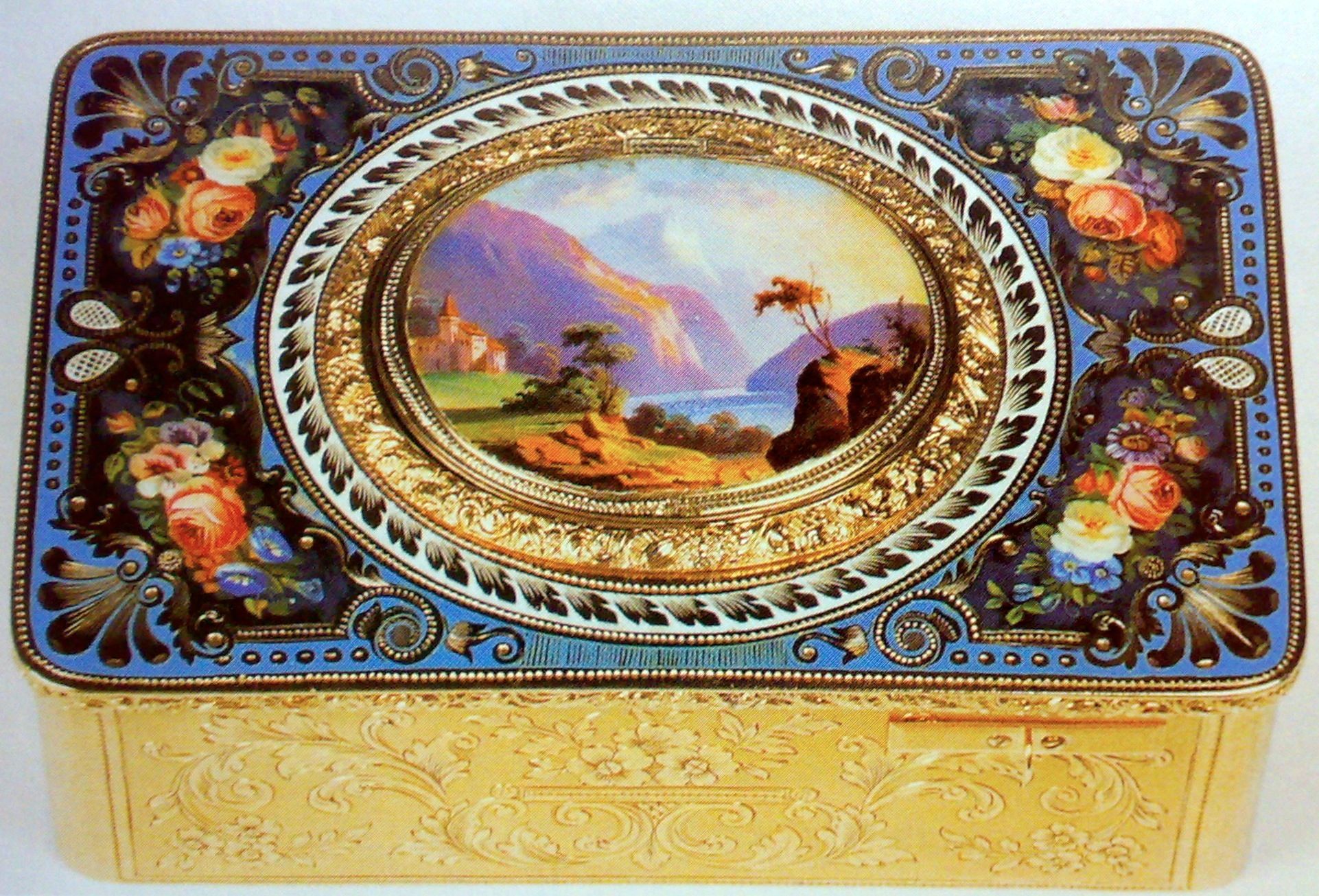 The closed enamel lid of a Bruguier box, painted with a lake and mountains and surrounded by floral decoration
