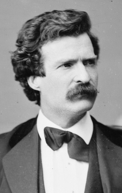 A studio portrait of the young Mark Twain with curly hair and a moustache.