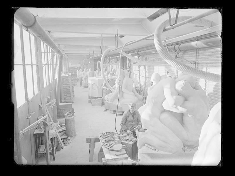 Vilhelm Broe beside a sculpture and a bench covered with hand tools in the stone-carving workshop at Frogner.