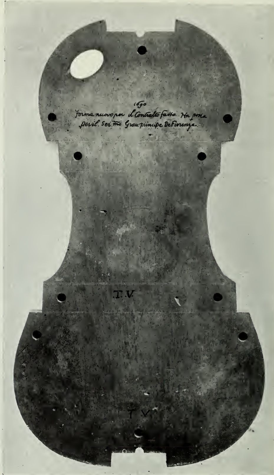 A wooden viola form with holes, block recesses and the letters T.V.