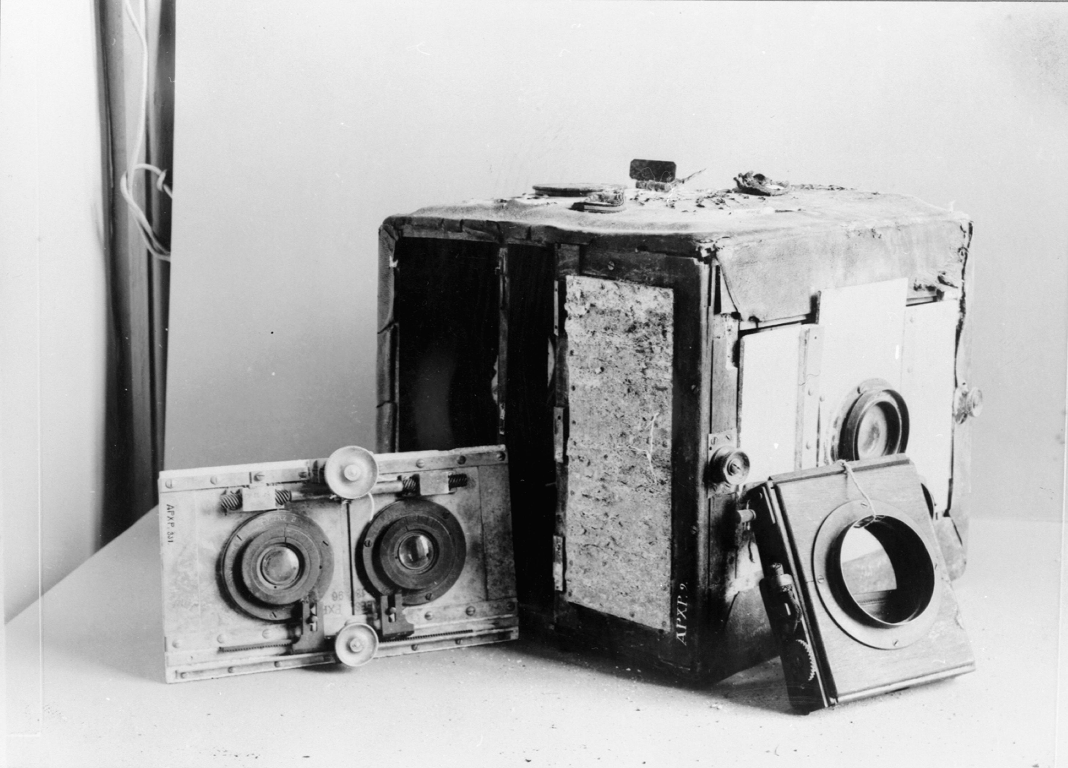 The recovered camera with a two-lens board beside it and its shutter leaning against the front