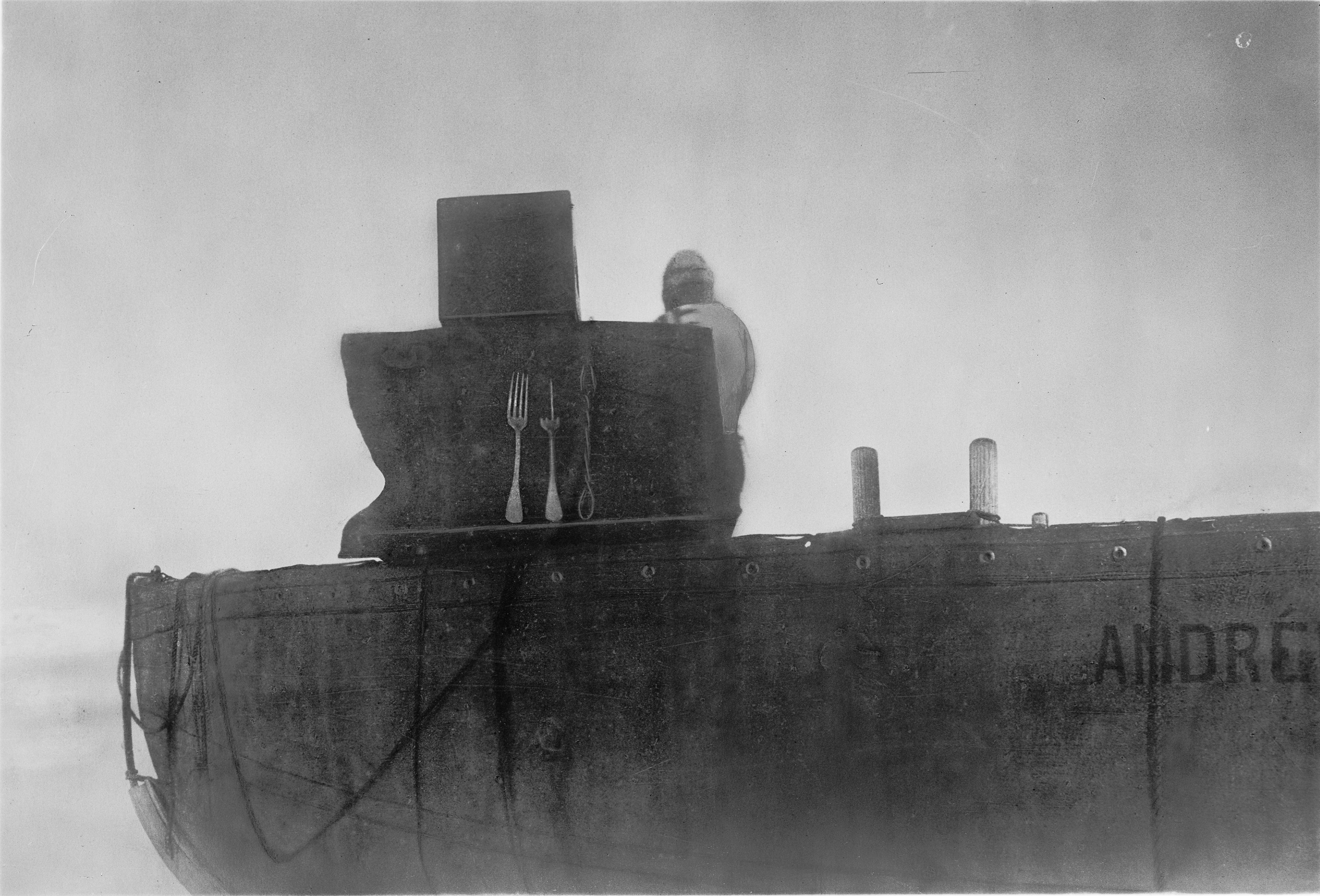 Three forks arranged against a dark backing above the side of the expedition boat