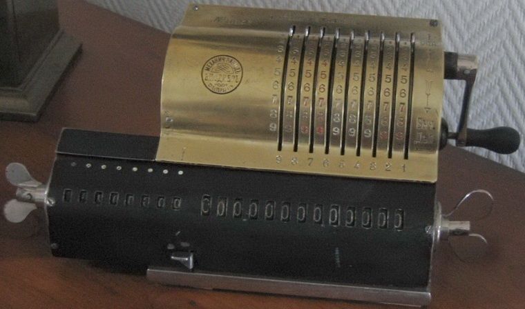 Brass-covered Odhner calculator with nine setting levers, two rows of number windows and a crank on the right