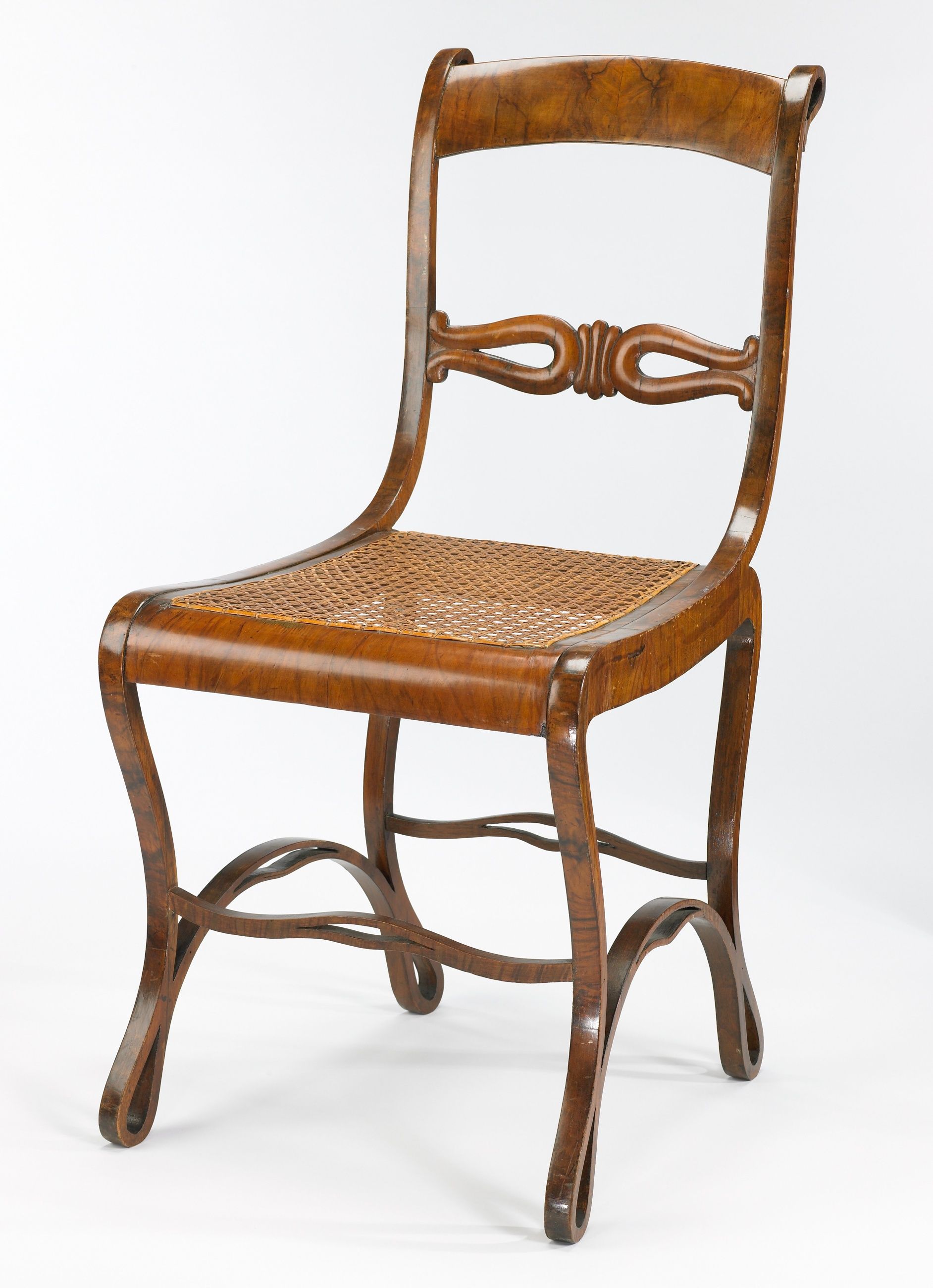 An early Boppard chair with walnut veneer, a pierced back rail, cane seat and curved stretchers