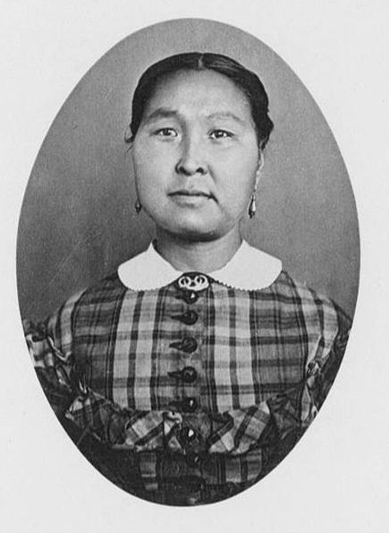 Taqulittuq in a photographic portrait wearing a checked dress