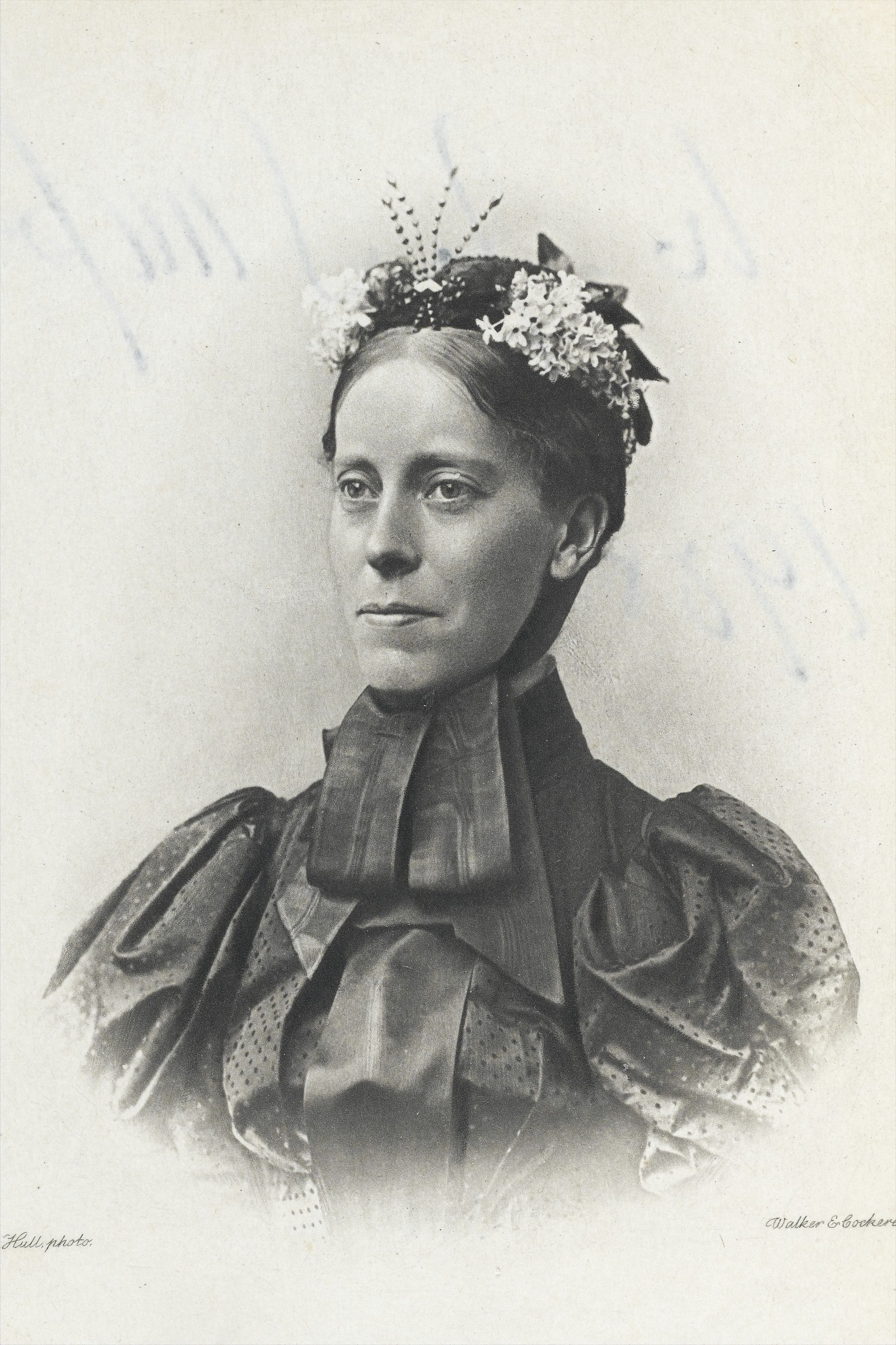 Mary Kingsley in a published photographic portrait, wearing a high collar and flowers in her hair