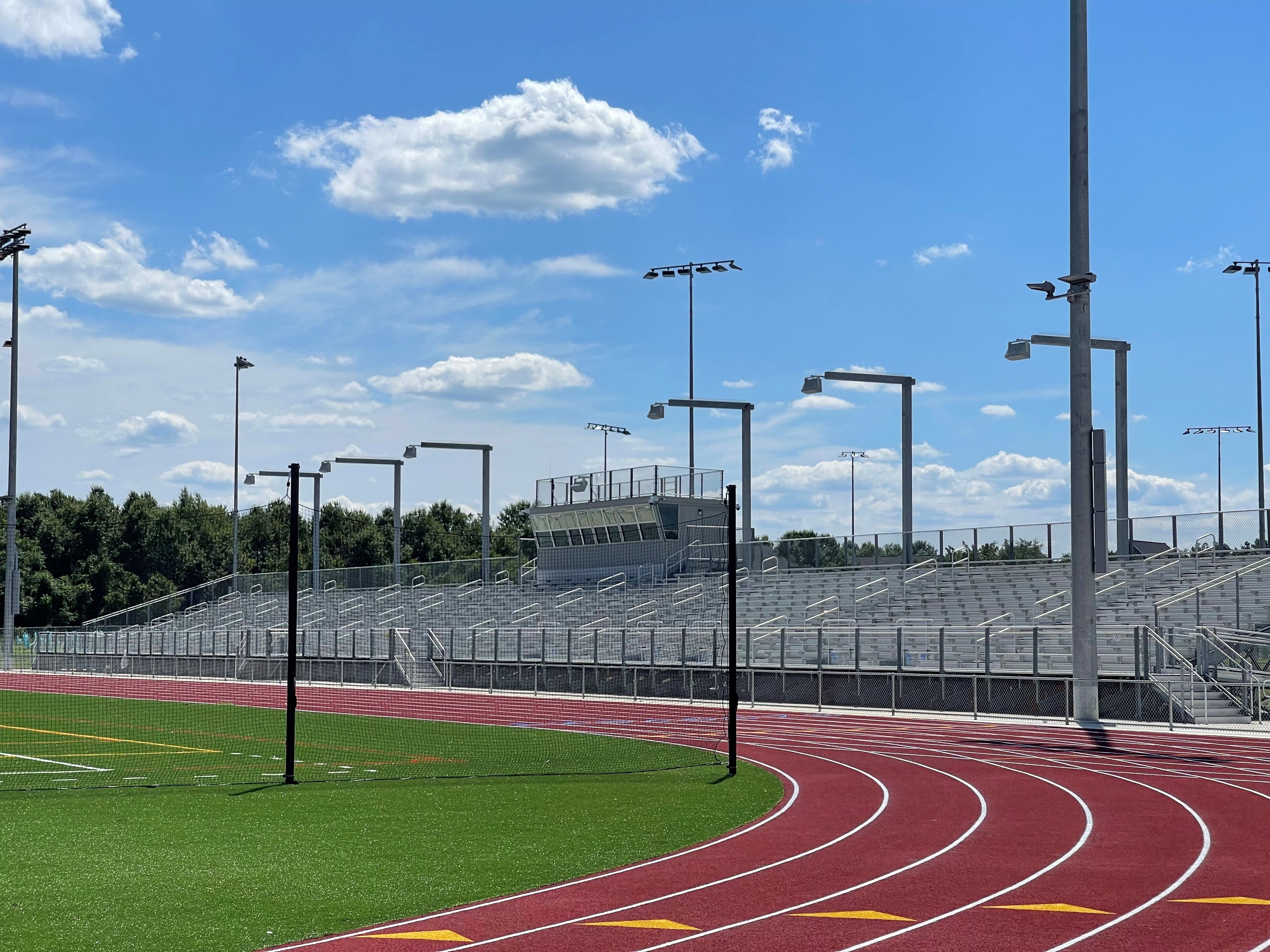 Speakers mounted on a pole above metal bleachers / stands