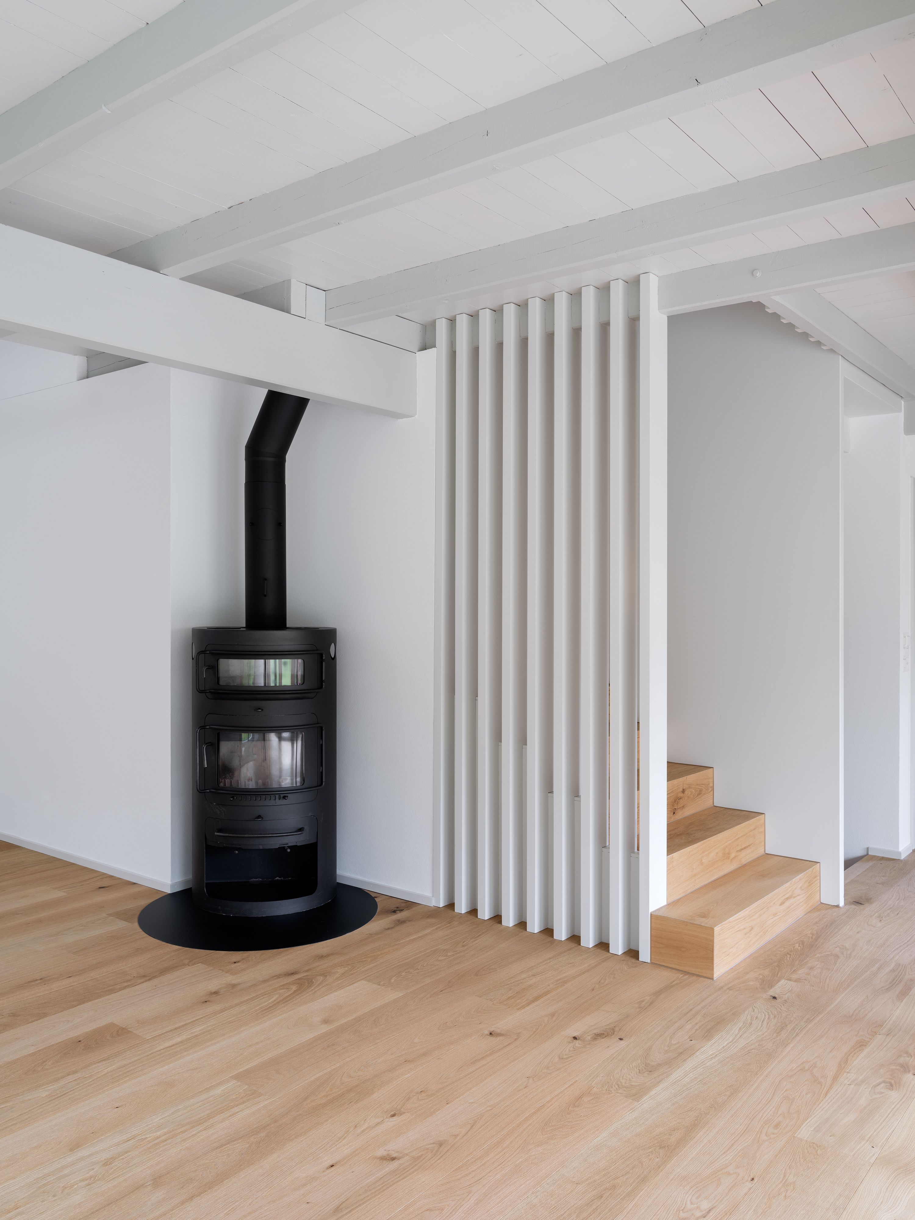 EFH Wohlen Neue Treppe mit Sichtschutzlamellen und altem Ofen