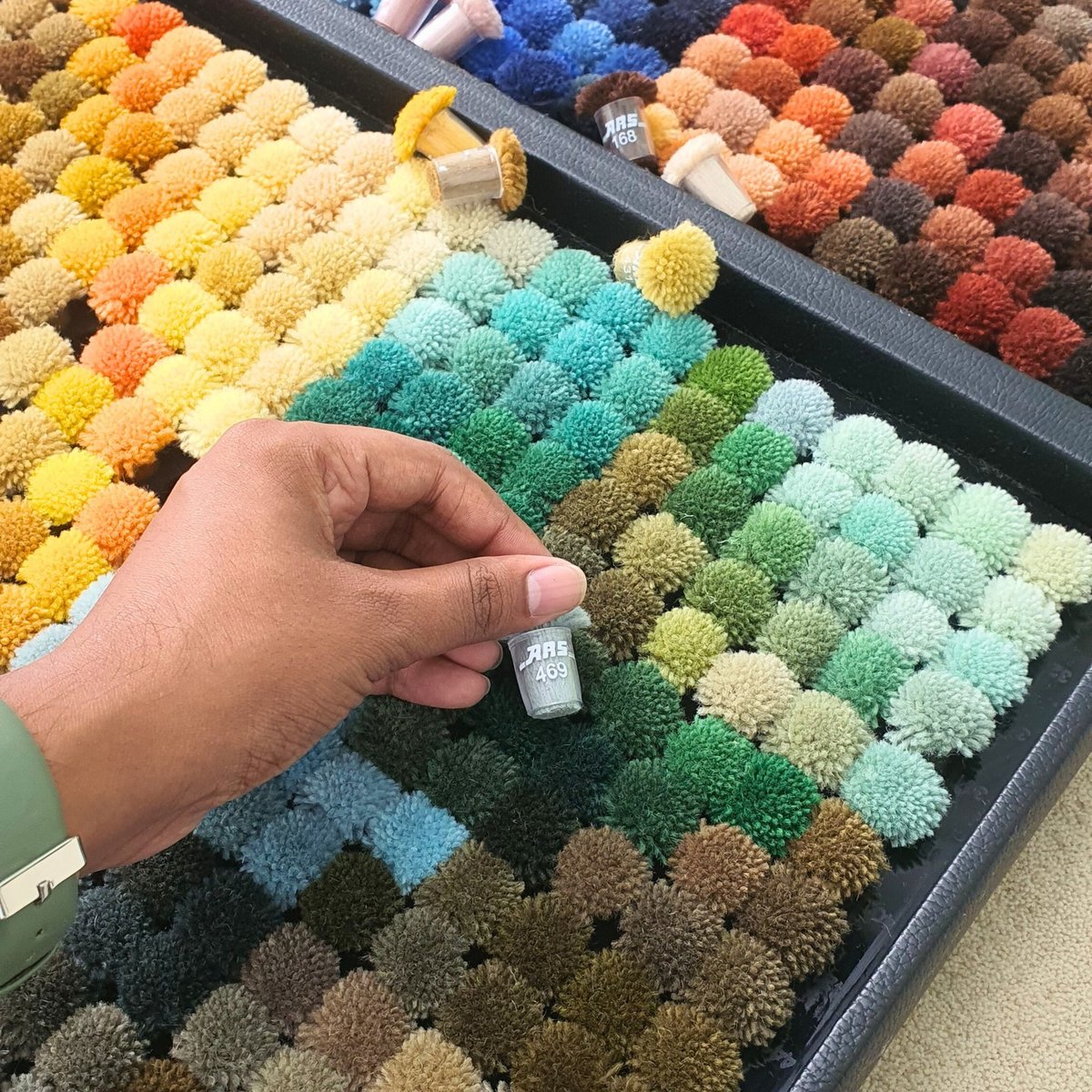 esigner reviewing custom rug color and wool samples on a work table