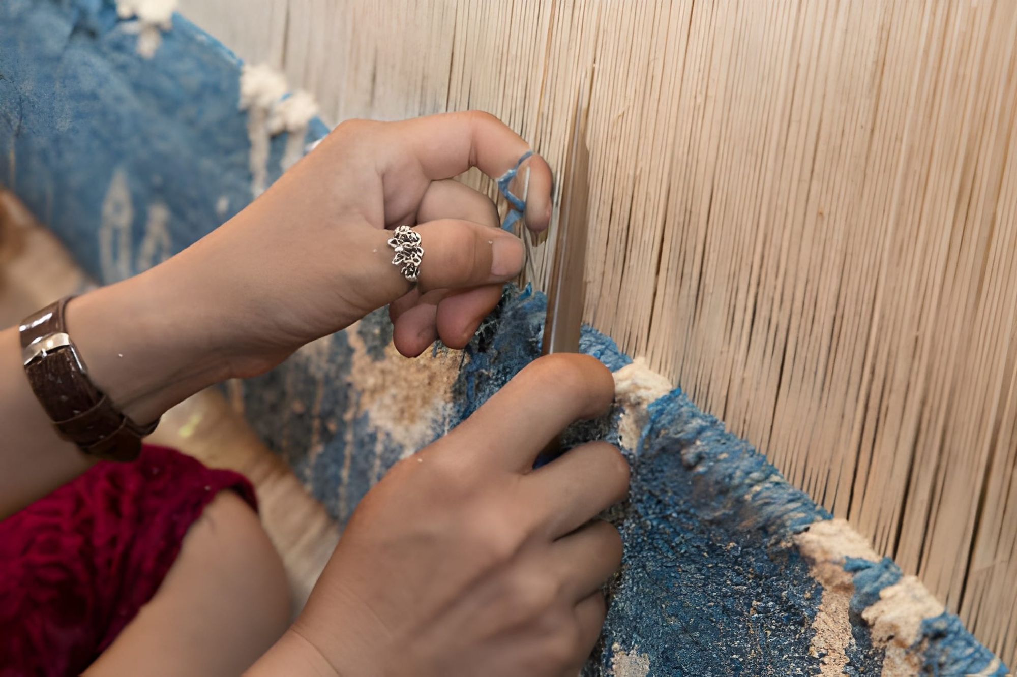 Close up of individual hand tied knots around vertical warp threads