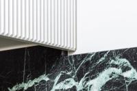 Detail of marble and corrugated cabinetry intersection