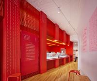 Milk & Forth Ann Arbor is organized by an angled red wall that cuts through the space