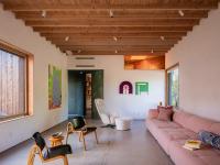 A thick roof plane creates space for "light scoop" skylights that bring reflected daylight into the rooms.